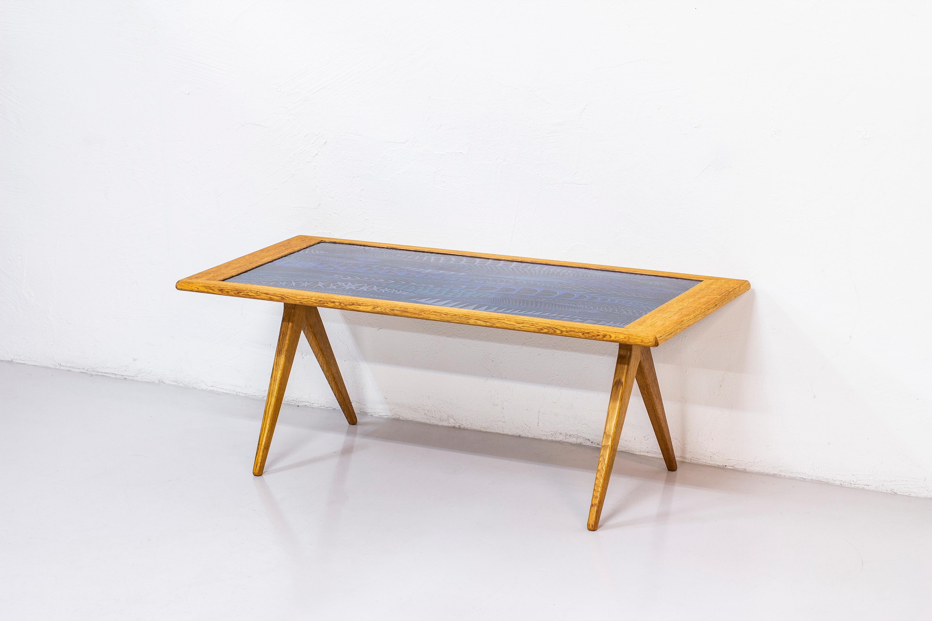 Sofa/occasional table designed by David Rosén and produced by Nordiska Kompaniet, NK. Made from solid oak with brass details and enamel surface designed by Stig Lindberg. The enamel plate was produced by Gustavsberg in their bathtub factory. Signed