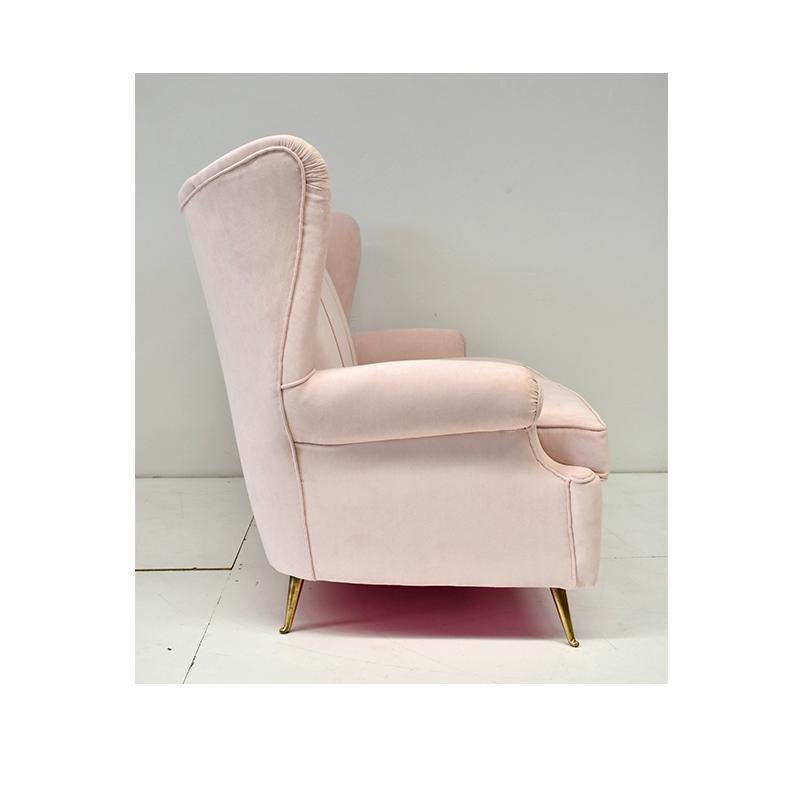 Vintage sofa, made in the sixties, Italian manufacture.
The sofa features brass feet with pink fabric upholstery.
  