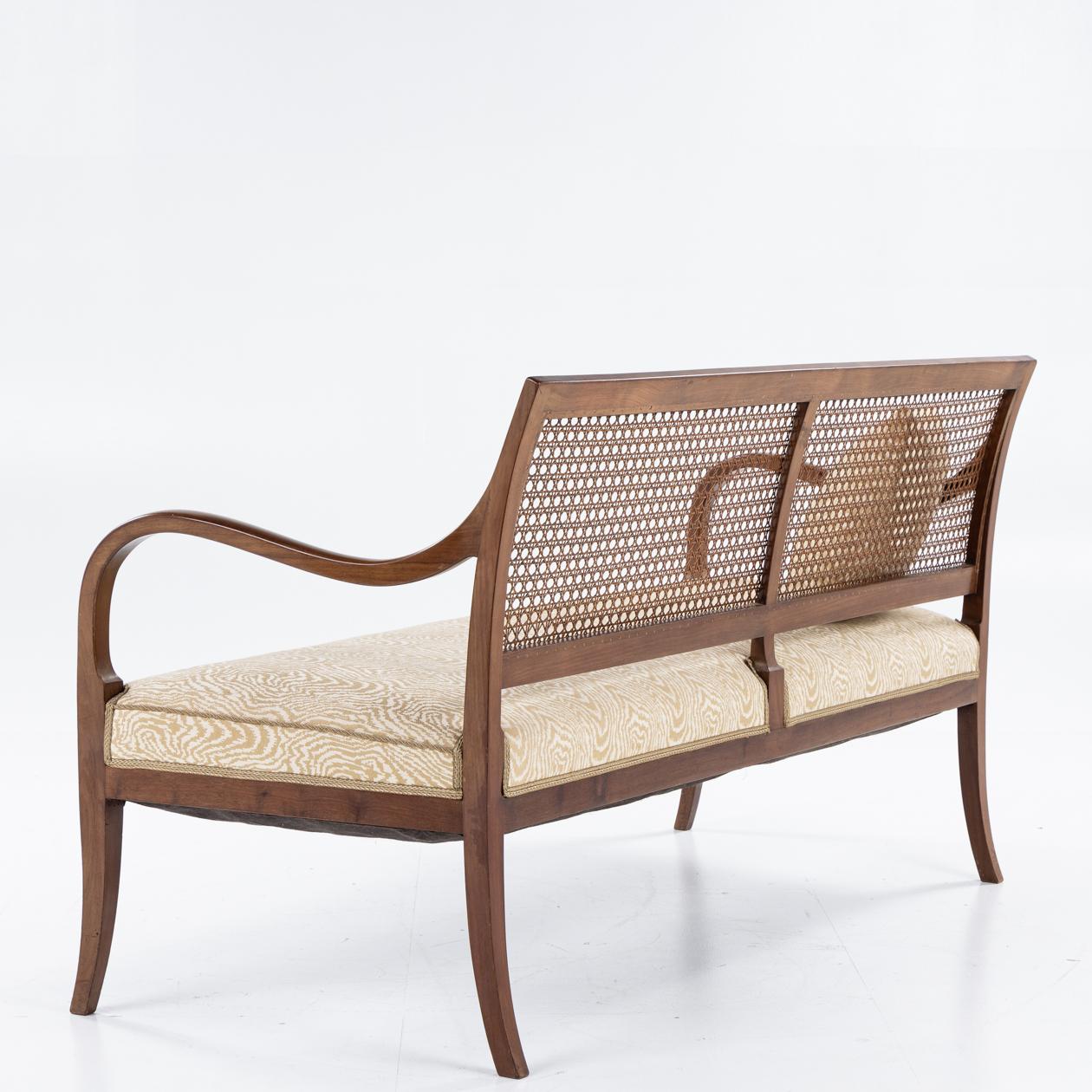 Sofa with curved arms in mahogany, french cane and wool. By Frits Henningsen.