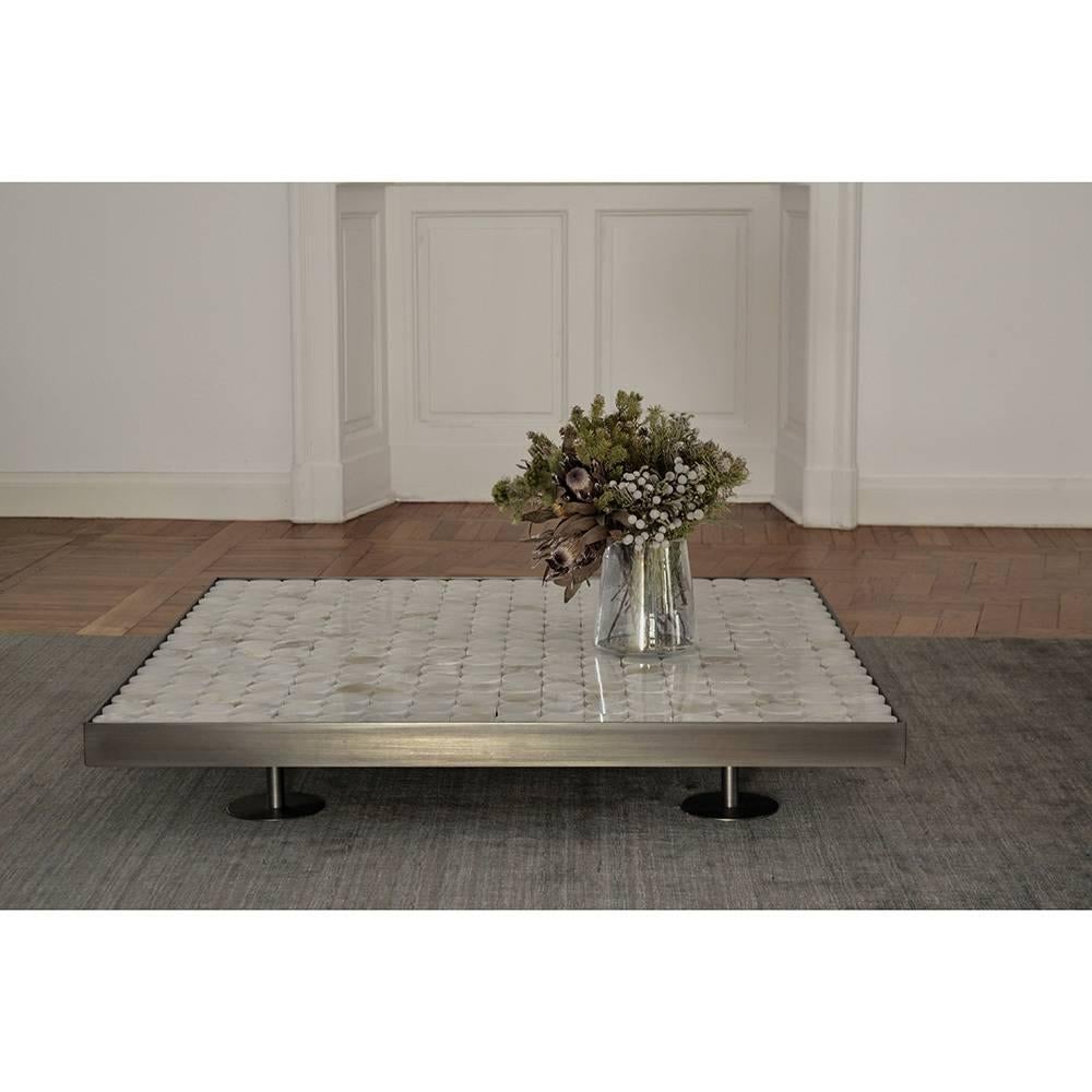 Part of the Sofia series, this exquisite coffee table features structure and feet made in bronzed steel. The top is accented by cylinders of onyx that evoke the eternal beauty of this Classic material, creating striking patterns of light on the
