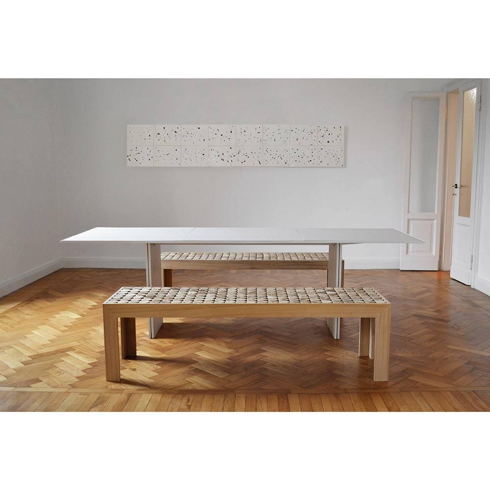 This striking bench is made entirely in sold wood by the hands of master carpenters and each piece is a one-of-a-kind object made with artisanal methods. Its structure supports a hollow top filled with wood cylinders that give its texture a dynamic