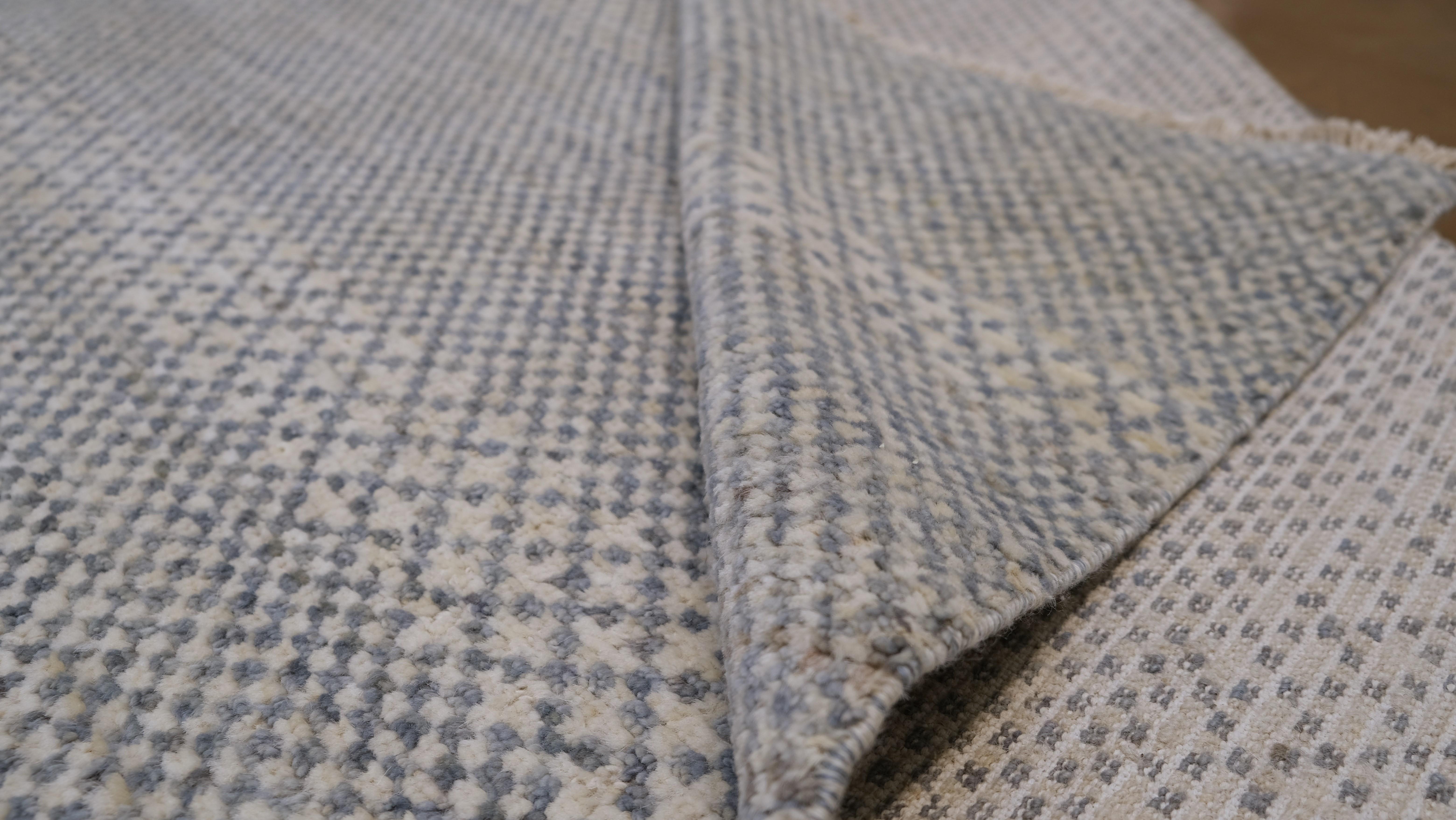 Dieser elegante, handgeknüpfte Wollteppich mit seinem minimalistischen Streifendesign in beruhigenden Blau- und Elfenbeintönen wertet Ihre Einrichtung auf. Dieser in Pakistan gefertigte Teppich verkörpert Schlichtheit und Raffinesse und ist damit