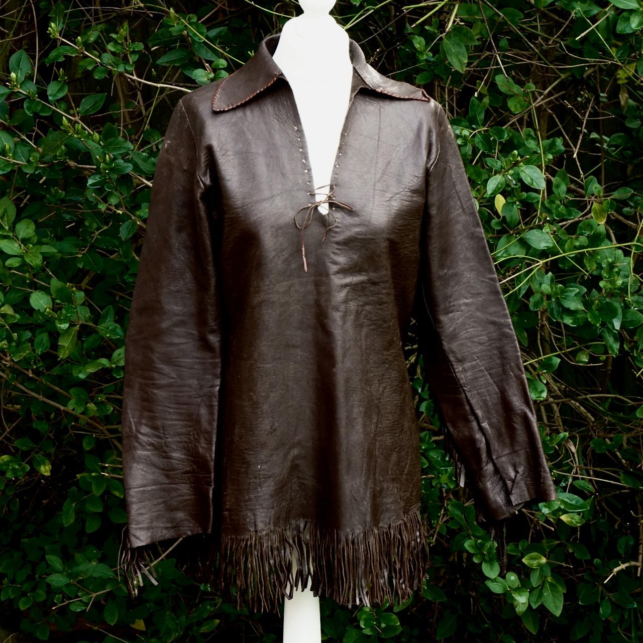 Amazing soft brown leather top, with fringing along the sleeves and bottom. It has leather lacing to the front, and the collar is finished around the edge with contrasting hand stitching. The top was purchased at Lord John of Carnaby Street, London,