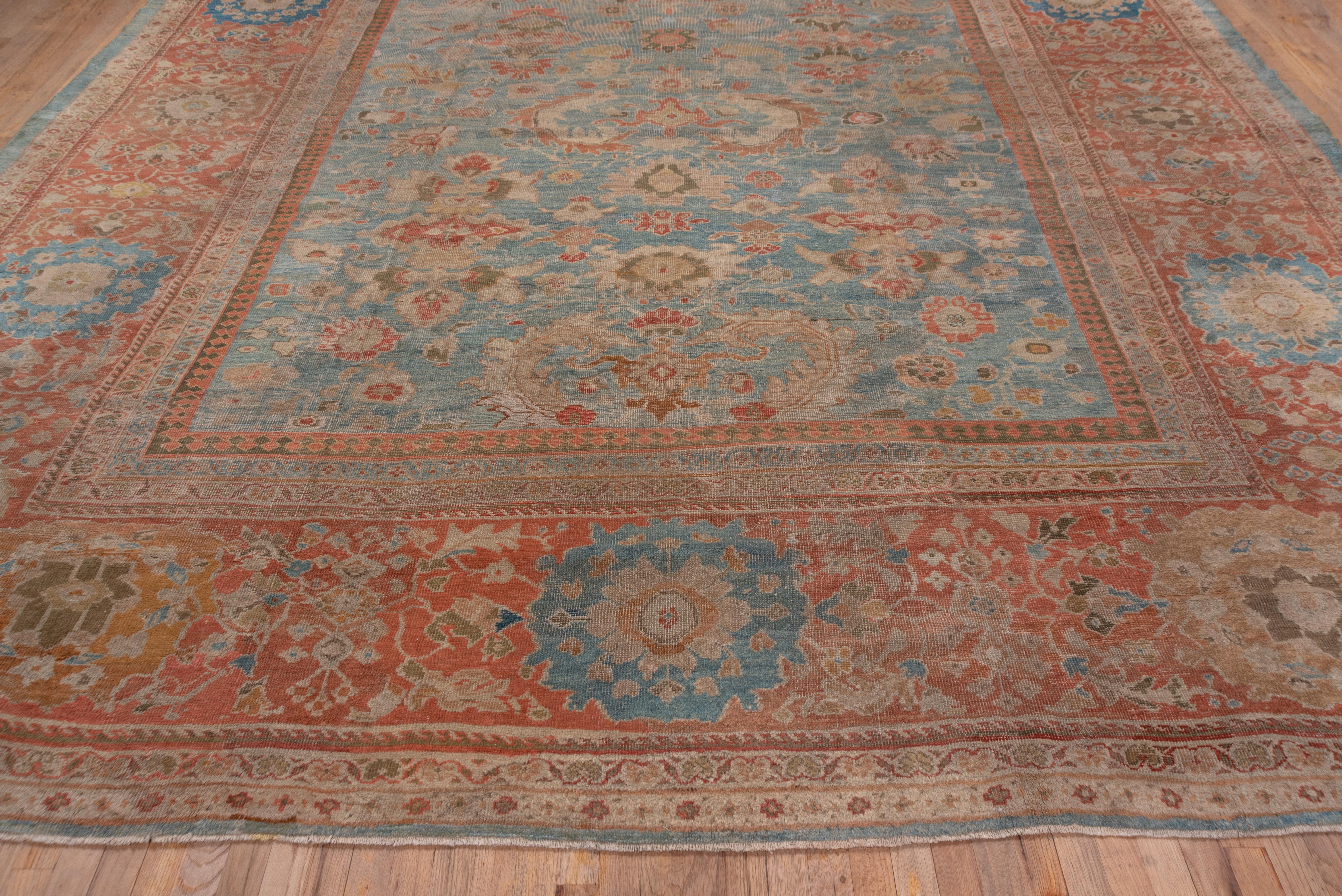 Eine breite Rostbordüre mit Riesenrosetten und komplexen floralen Füllungen umrahmt das himmelblaue Allover-Musterfeld mit C-förmigen Blättern, kleinen Palmetten und Vajra-Kartuschen. Prächtiger Teppich mit einer kühnen Bordüre, die größer