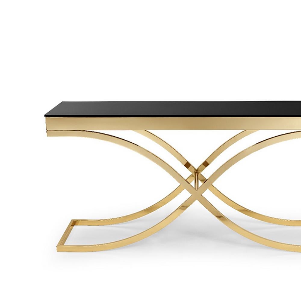 Console table soft cross with structure in metal
in gold finish and with tempered black glass top.
Also available in chrome finish.