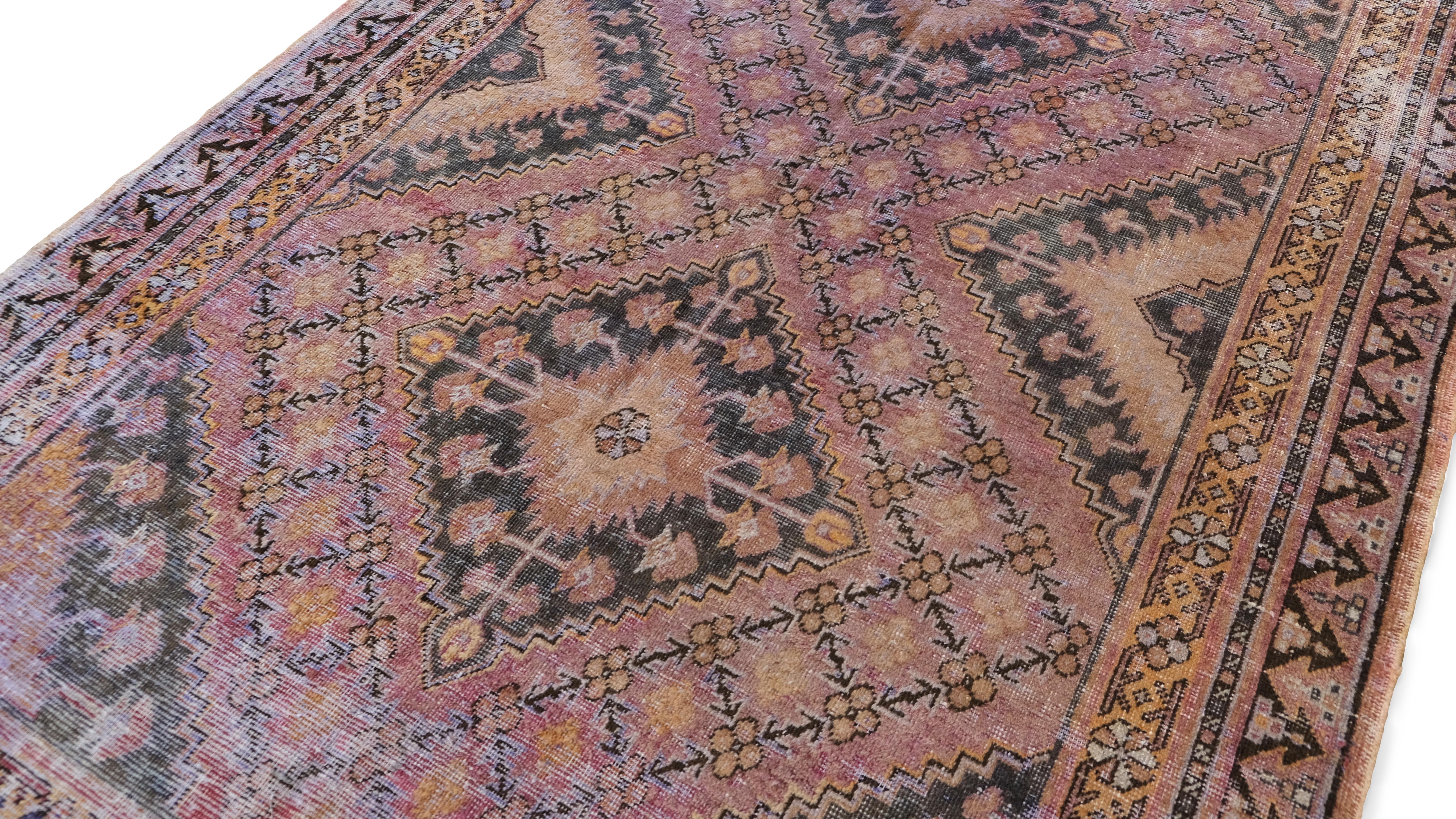 Dieser handgeknüpfte Wollteppich im Vintage-Stil verkörpert die reichen Webtraditionen des Kunsthandwerks. Mit seinem komplizierten Rautenmedaillonmuster, umgeben von kunstvollen geometrischen und floralen Motiven, spiegelt dieses Stück die