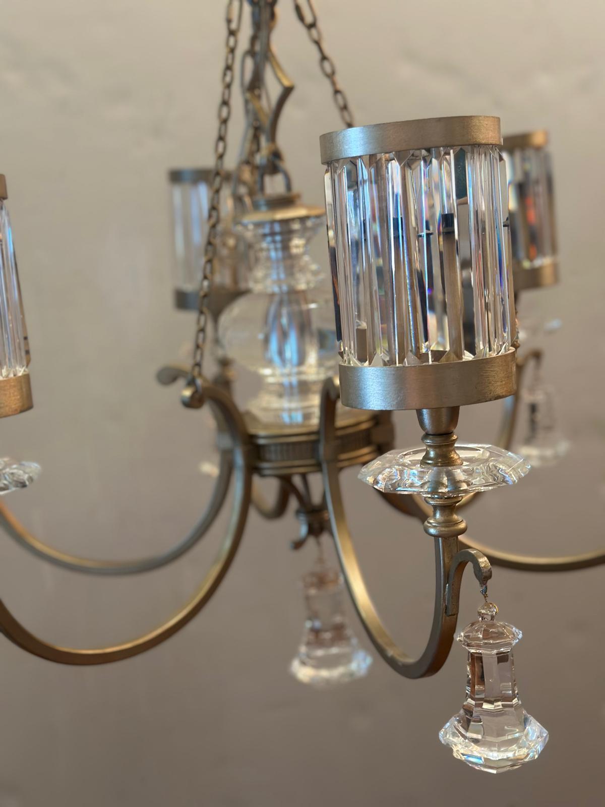 Lampadario rotondo realizzato a mano con finitura in foglia d'oro e paralumi in cristallo sfaccettato. 