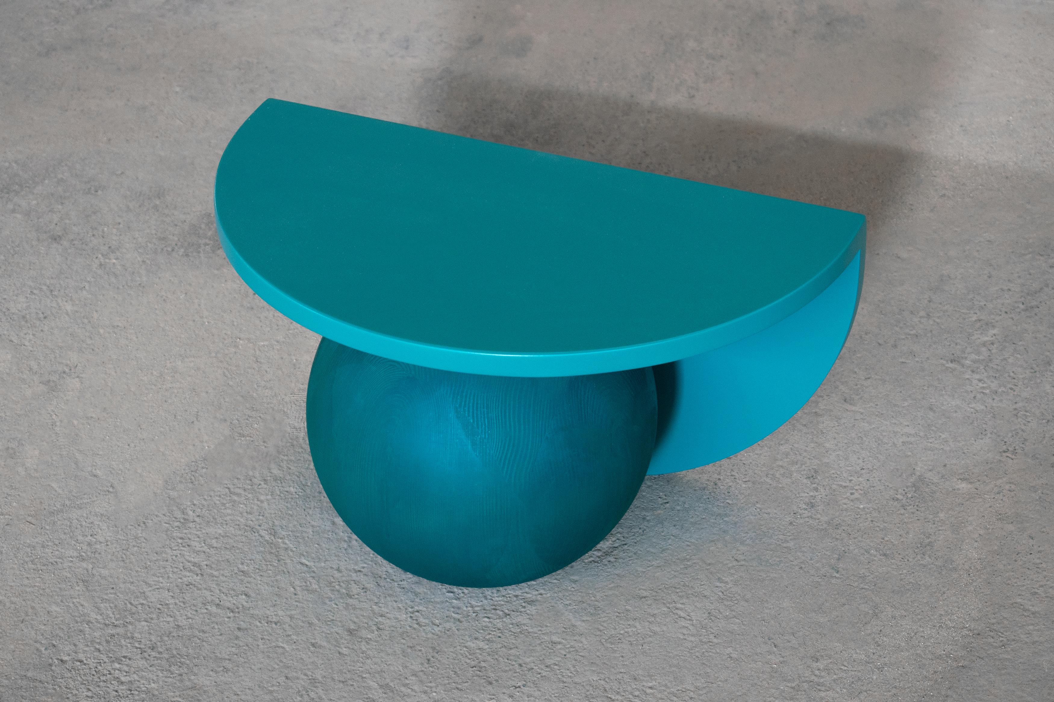 MDF surfaces and a Swedish pine solid wood sphere lacquered in dead matt petrol green colour. 

This compact low level piece elaborates the curved profiles of the series in three dimensions. made out of two intersecting half-moon surfaces