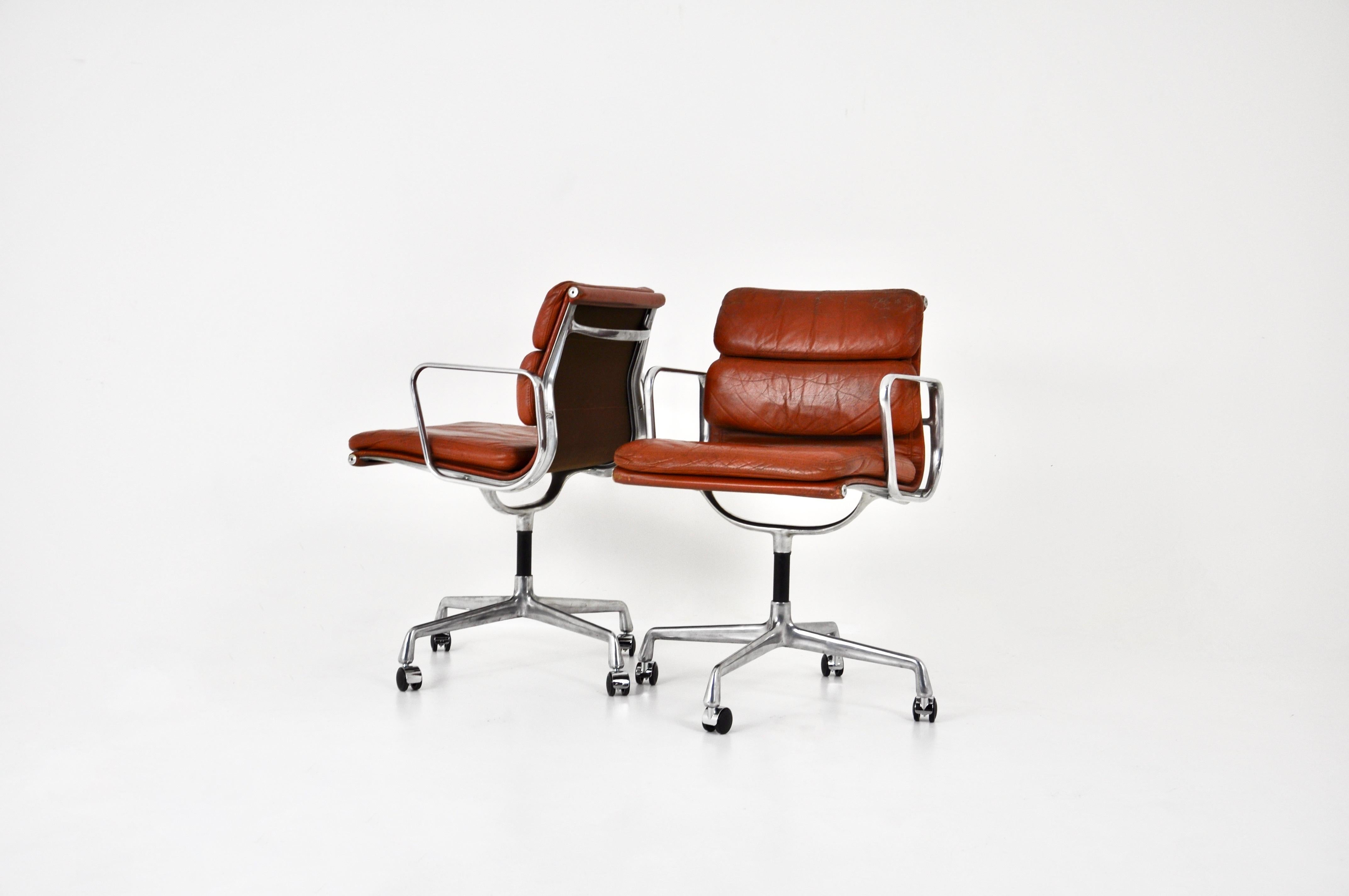 Brown leather armchairs with aluminium base. Turns on itself. Dimensions: seat height 57 cm. Stamped Herman Miller.  Wear due to time and age of the chairs.