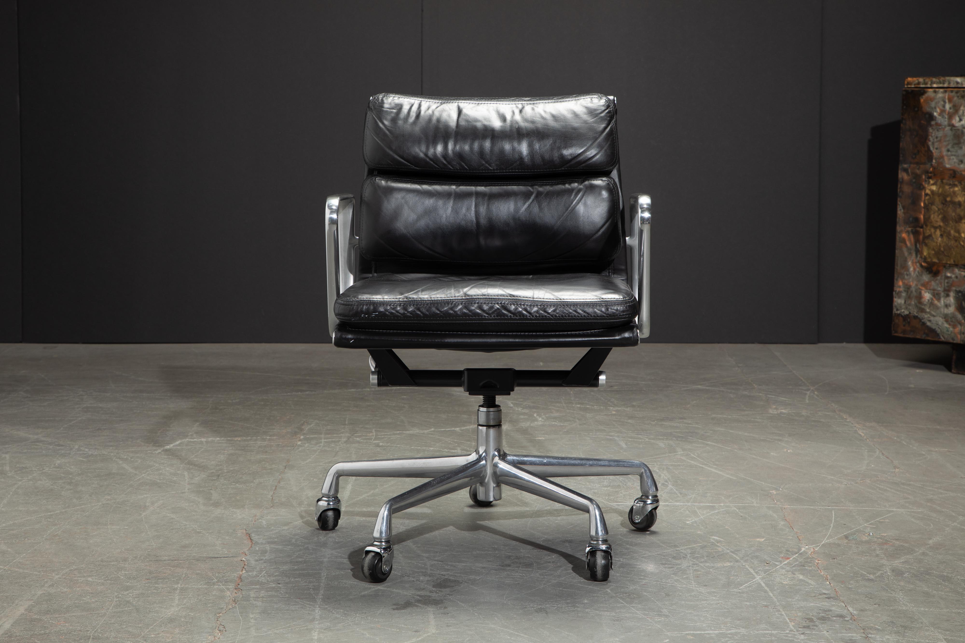 This sought after and in-demand black leather desk chair is the classic 'Soft Pad Management Chair' from the aluminum group line, designed by Charles and Ray Eames for Herman Miller. Featuring the original vintage black leather upholstery over
