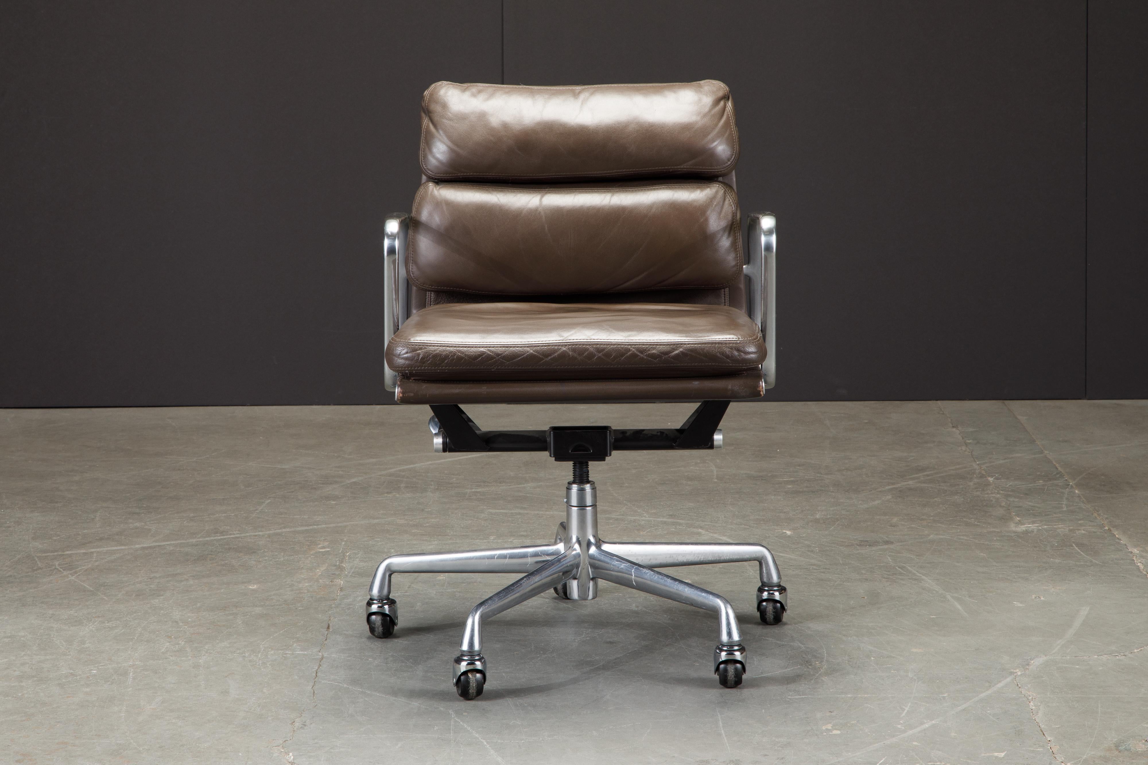 This sought after and in-demand leather desk chair is the classic 'Soft Pad Management Chair' from the aluminum group line, designed by Charles and Ray Eames for Herman Miller. Featuring its original vintage brown leather upholstery over five-star