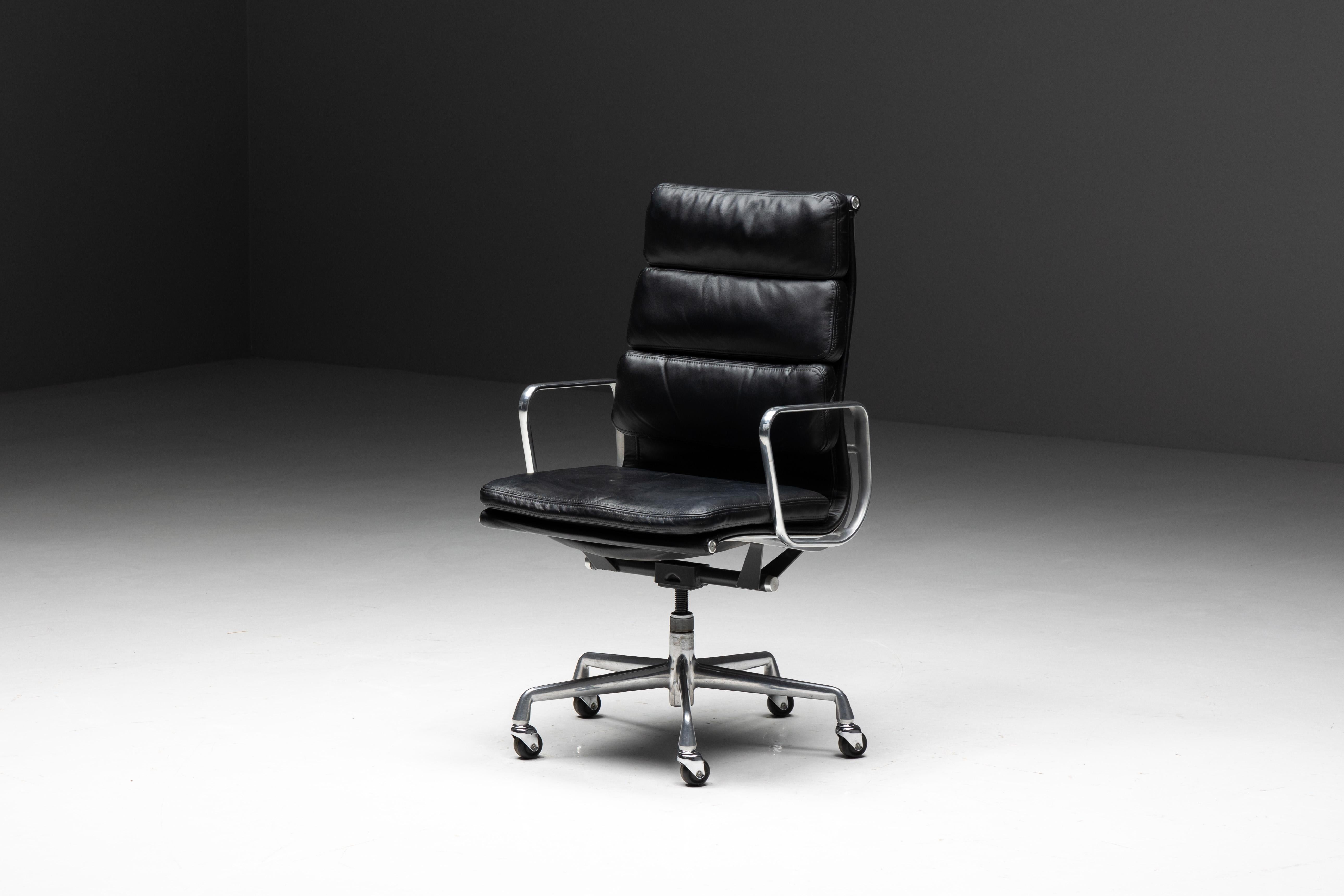 Charles and Ray Eames softpad office chair, produced by Herman Miller. This distinguished chair, crafted as the original USA edition for Herman Miller, features a sleek black leather seat and backrest, complemented by a chrome frame and armrests. An