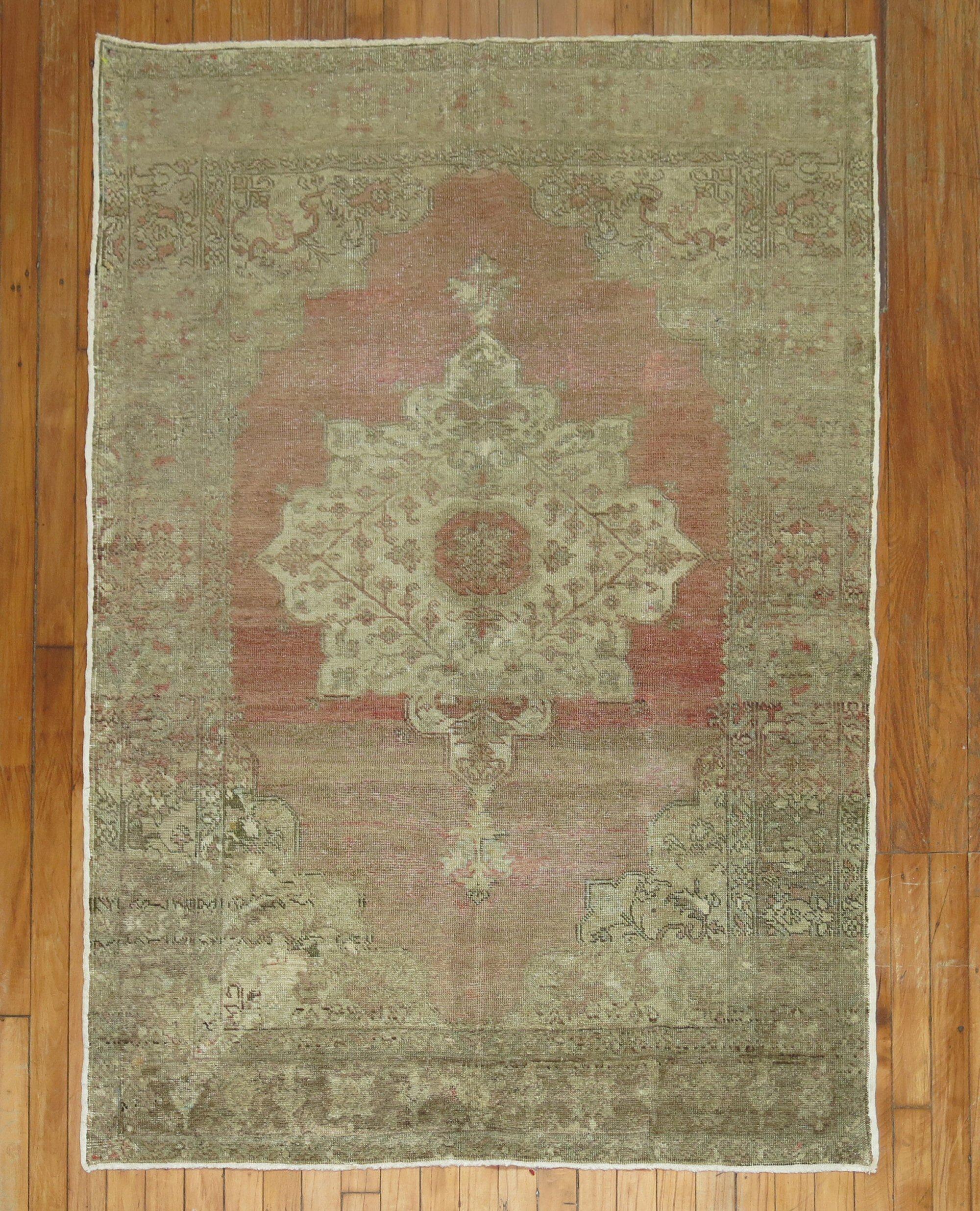 A vintage Turkish rug with a central medallion on a pink field. accents in white and brown

Measures: 3'10'' x 5'6''.