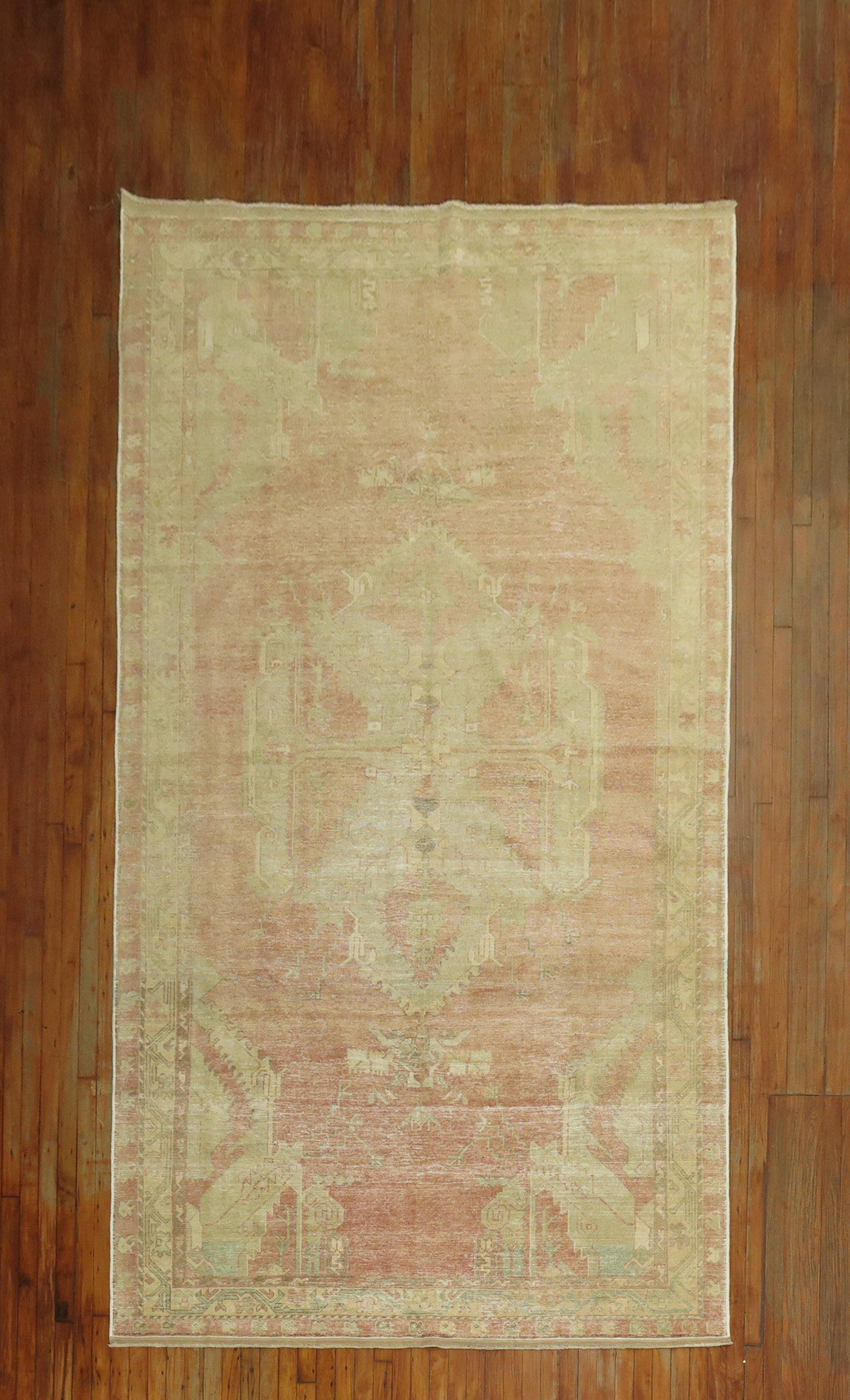 A vintage Turkish gallery rug with a central medallion on a pink field. accents in white and brown

Measures: 6'3'' x 11'9''.