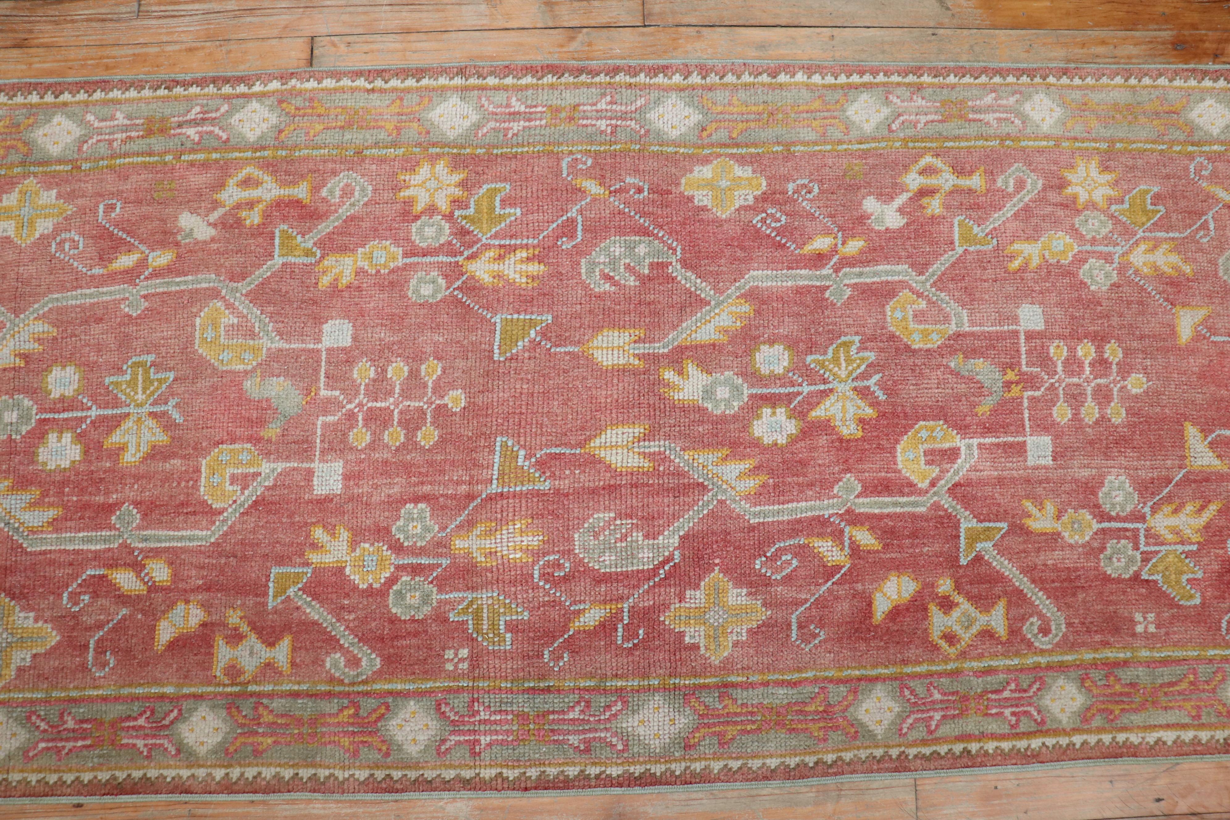 An antique Turkish oushak runner with an all-over design in a dominant soft red color, circa 1920

Measures: 2'6'' x 11'4''.