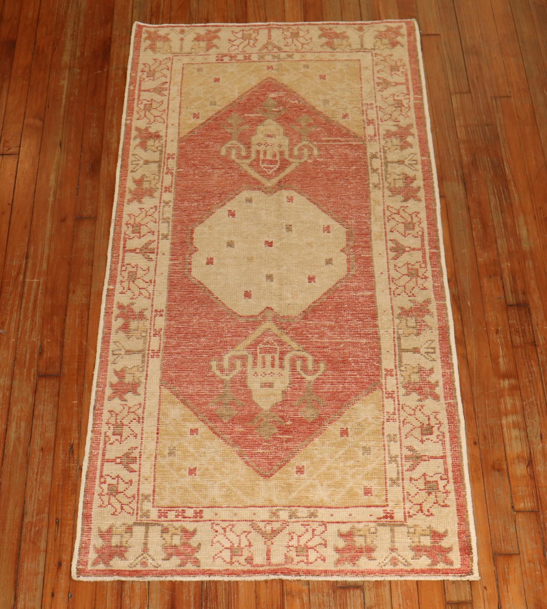 Scatter size vintage Turkish Oushak rug with medallion and border motif with a soft red field butterscotch, beige, light brown, ivory accents.

Measures: 2'10'' x 5'8''.