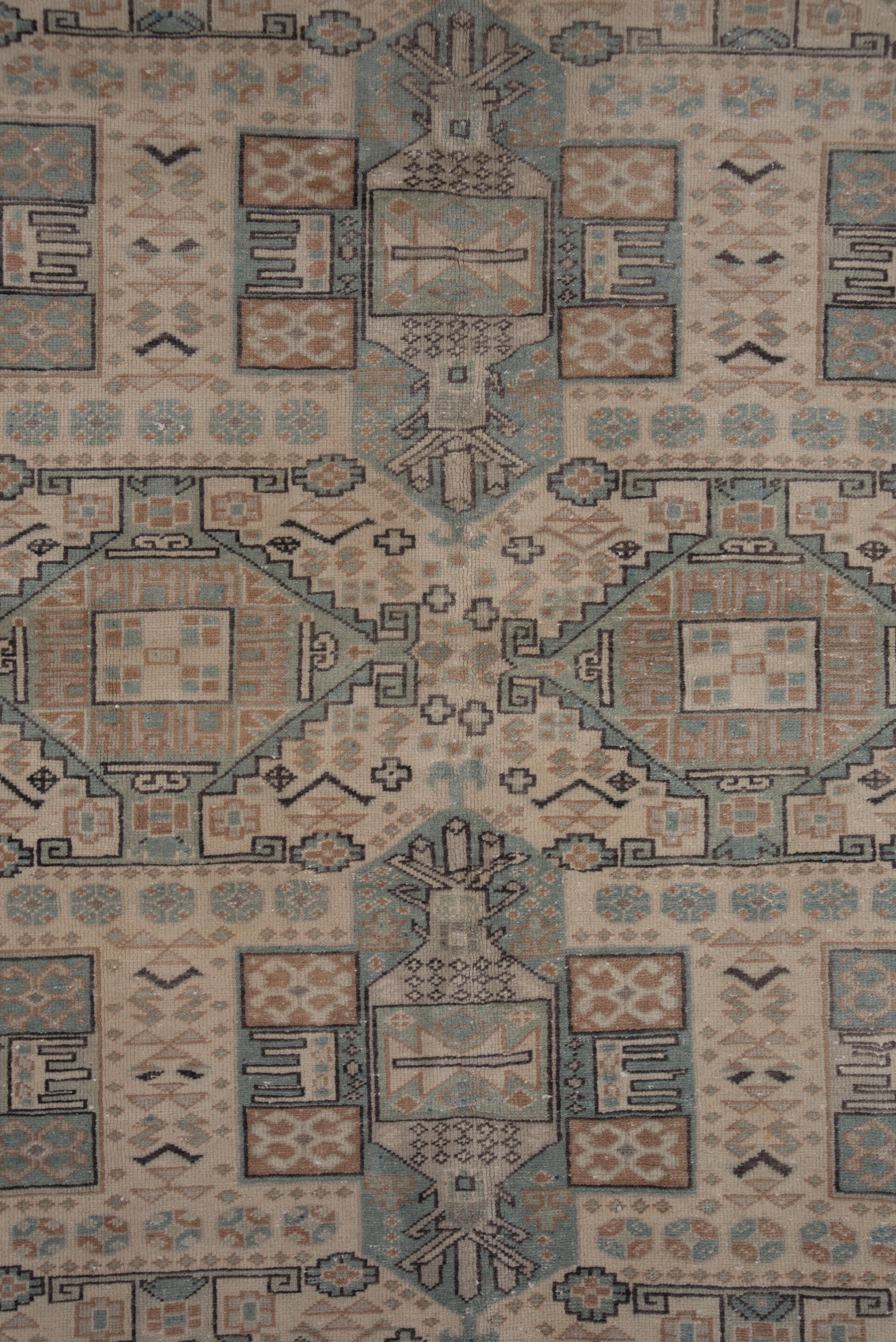 The almond ivory field displays an unusual quasi-Caucasian allover geometric pattern of stepped and hooked lozenges, hexagonal cartouches, rectangles,, rosettes and small fat crosses, all within an color matched border with full flowers and doubly