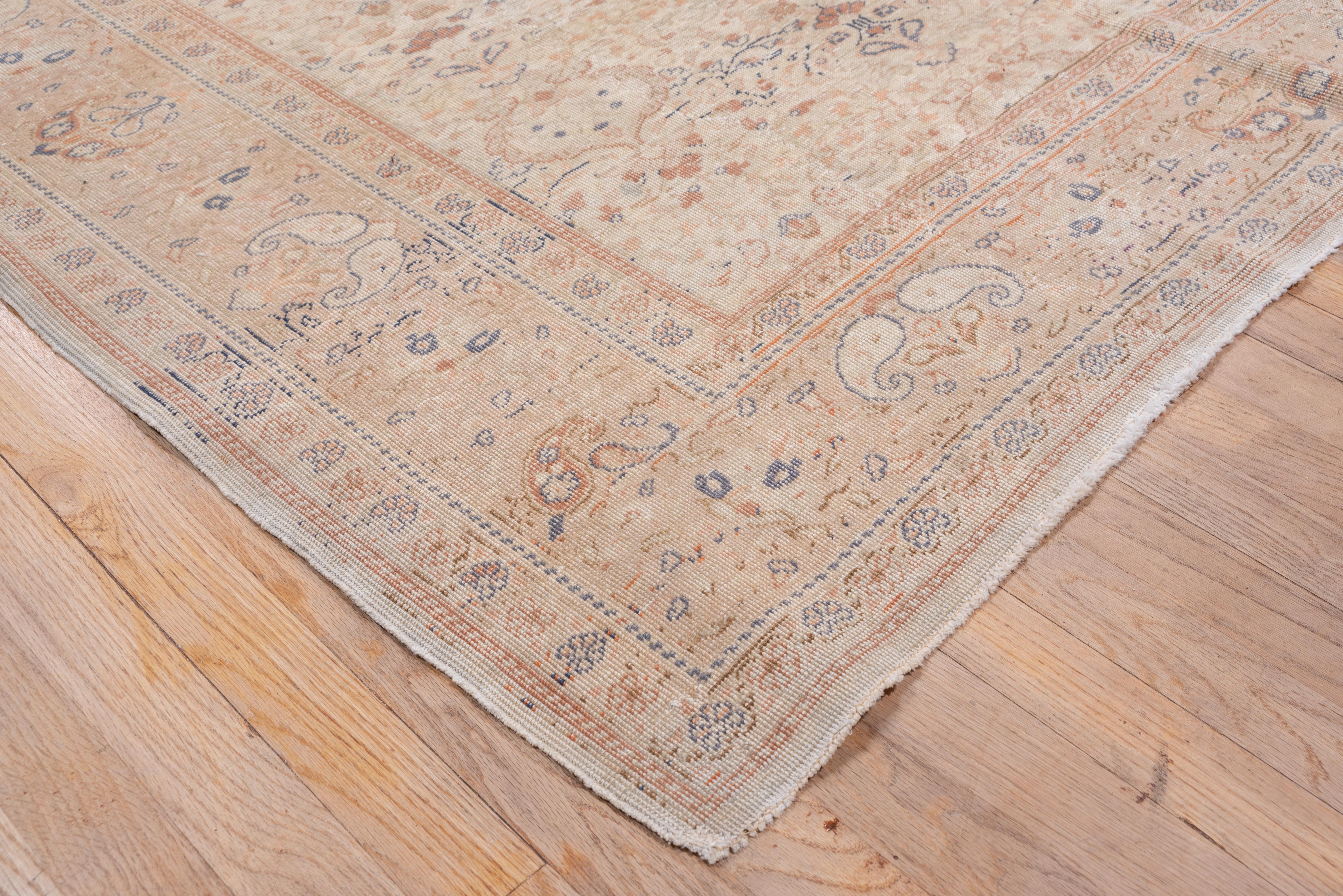 The ecru ground of this East Anatolian, medium weave town carpet shows a wiry flower and leafy spray repeating design, with acanthus defined open reserves in three columns. Blue, peach, brown accents. Straw paired boteh and palmette border.