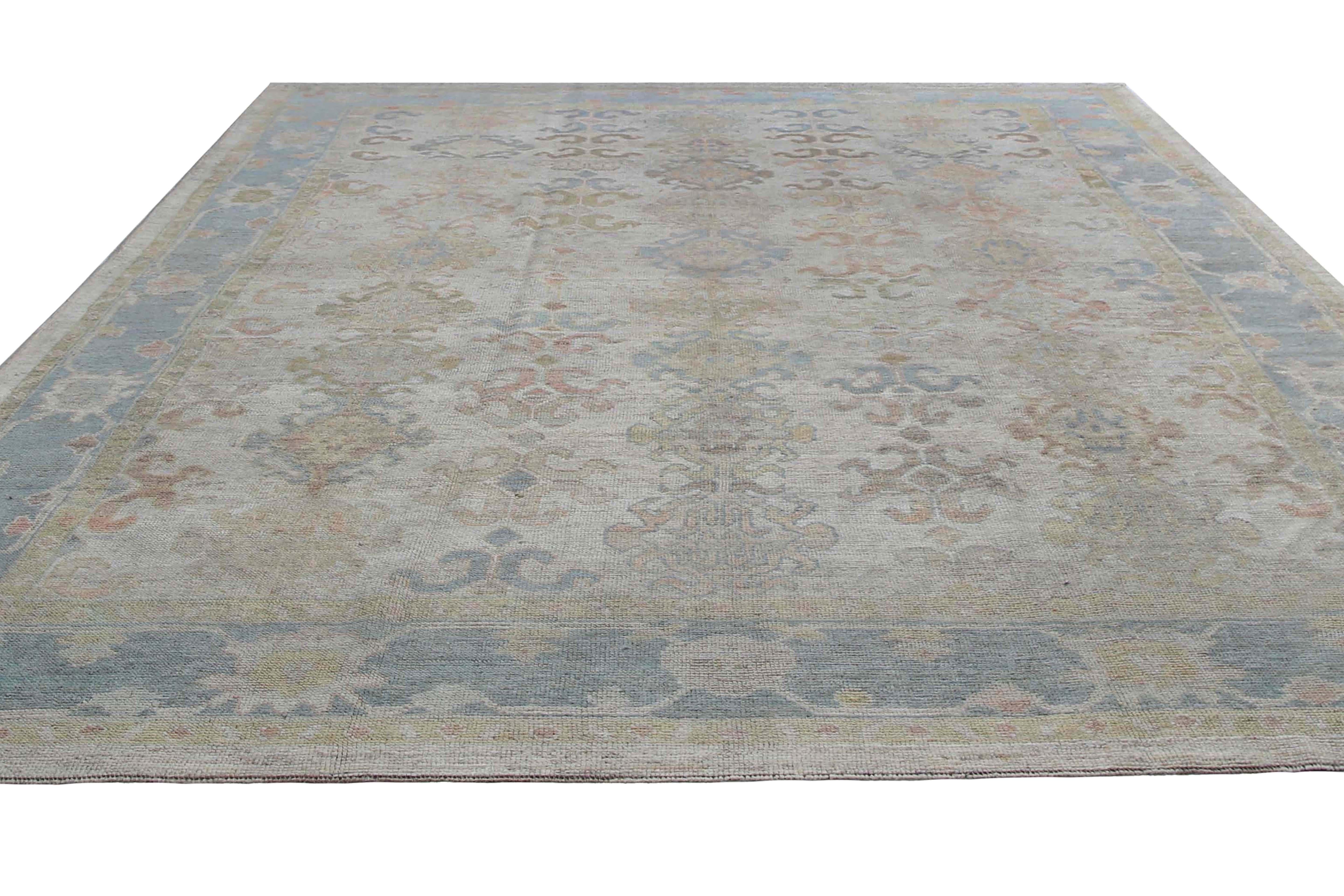 Introducing our stunning Turkish Oushak rug, measuring 10'2'' by 14'0''. This exquisite rug boasts a light beige background with eye-catching pops of color, including shades of blue, blush, green, and orange. The visible border adds an extra touch