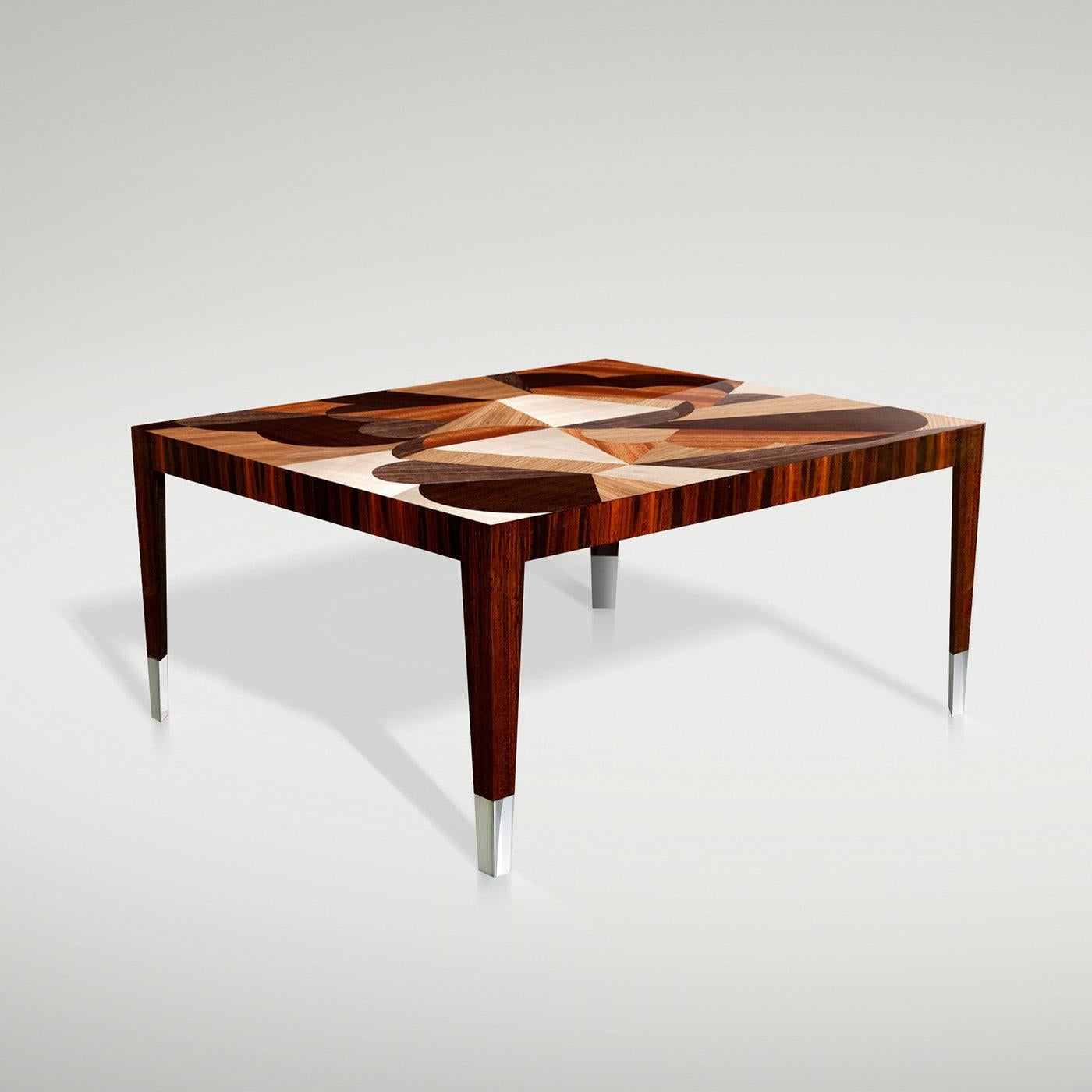 Équilibrant l'art et le design, cette table basse exclusive transforme une simple forme rectangulaire en œuvre d'art grâce aux incrustations fascinantes du plateau réalisées en combinant des bois d'érable blanc, de chêne, d'acajou, de noyer et de