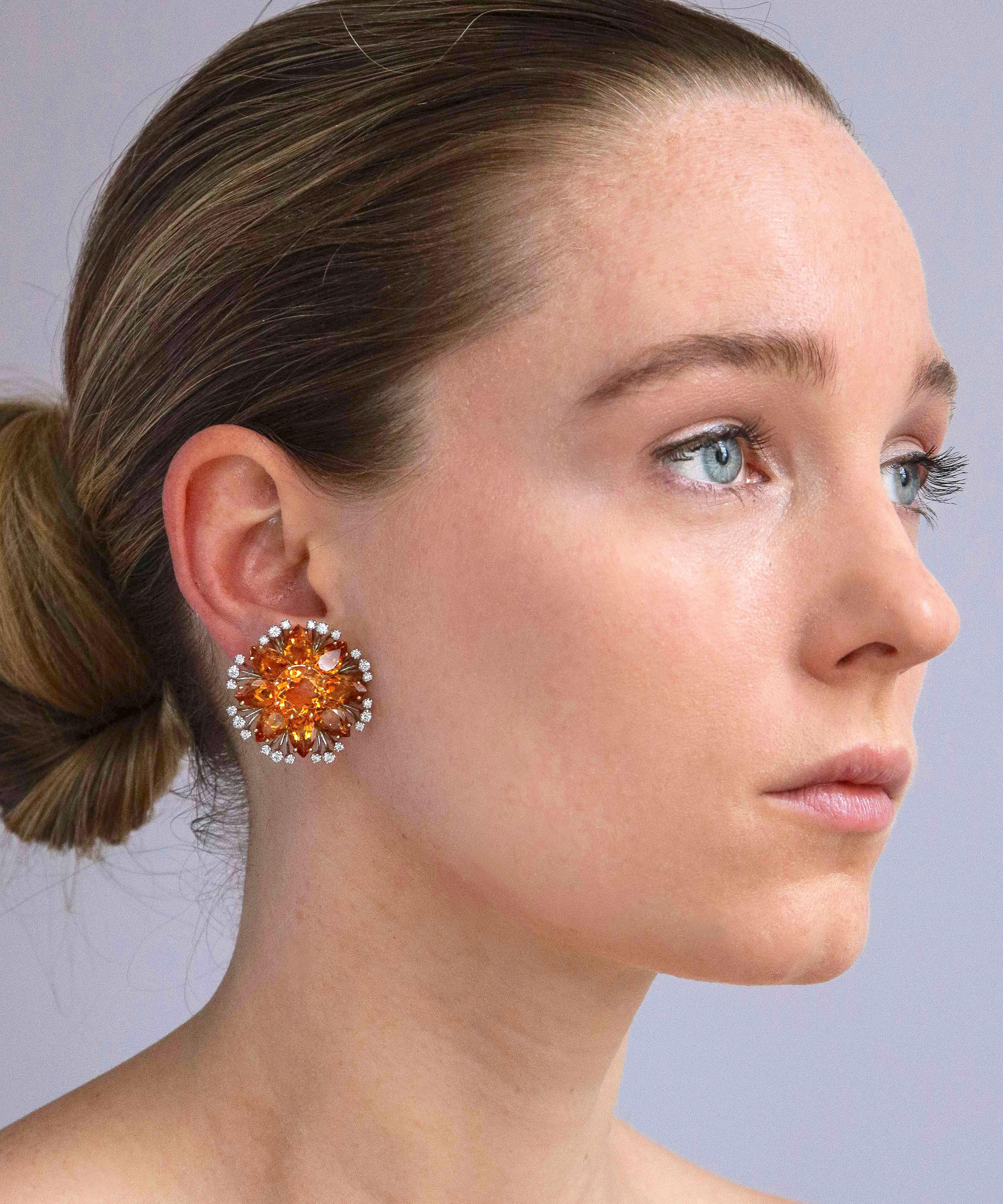 A striking pair of Sophia D. ear clips of 18K gold set with faceted bright amber citrine in a bold flower form softened by a delicate accent of diamond fringe. Marked Sophia D. and gold mark. Measuring 1 1/8 inch diameter. Weighing 19 Grams. 