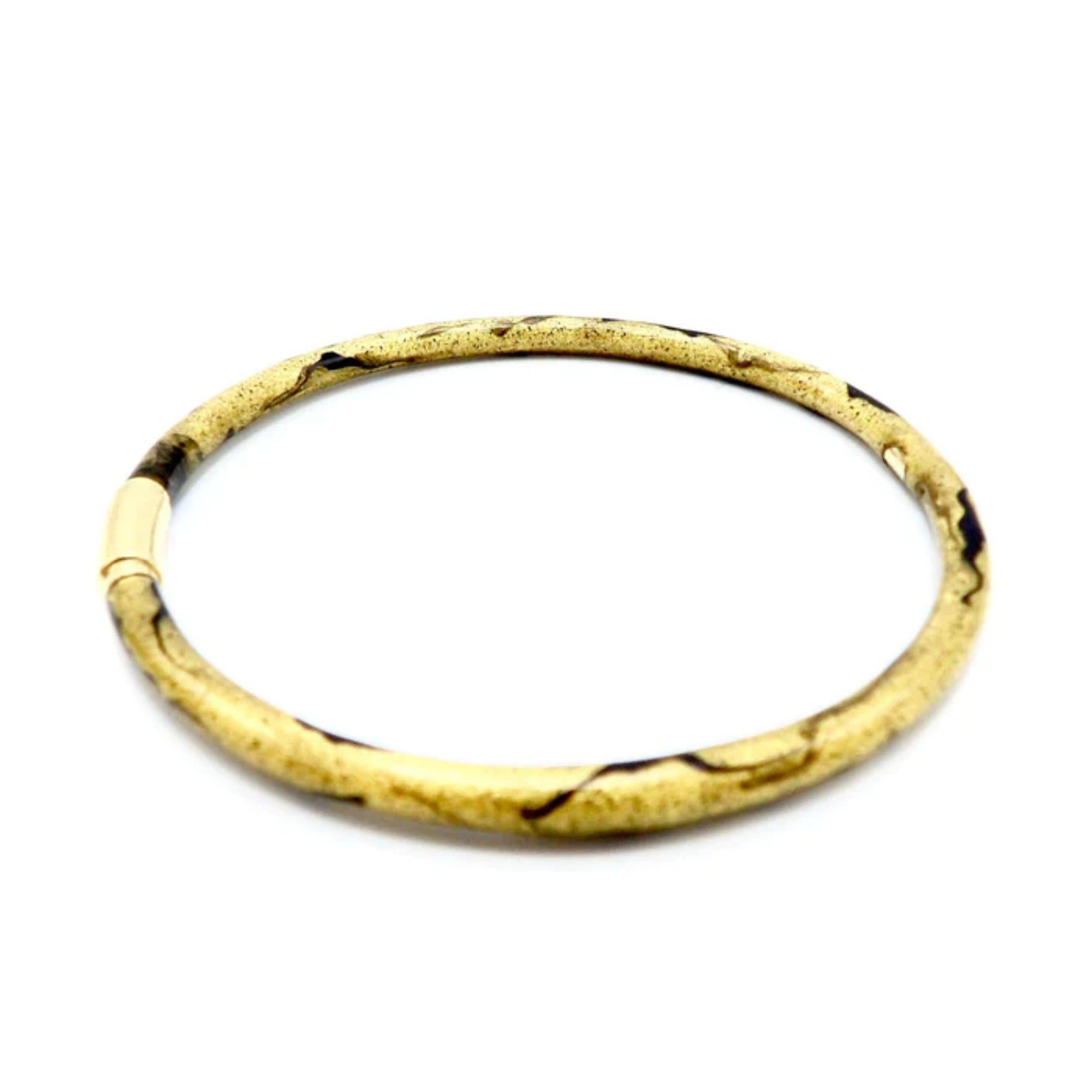 Soho 18K Gold Enamel Golden Calligraphic Stripe Bangle Bracelet, circa 2010
 
This gorgeous SOHO Enamel Bangle Bracelet was handcrafted in Italy circa 2010 in a beautiful golden enamel with a black calligraphic stripe motif. SOHO Jewelry combines