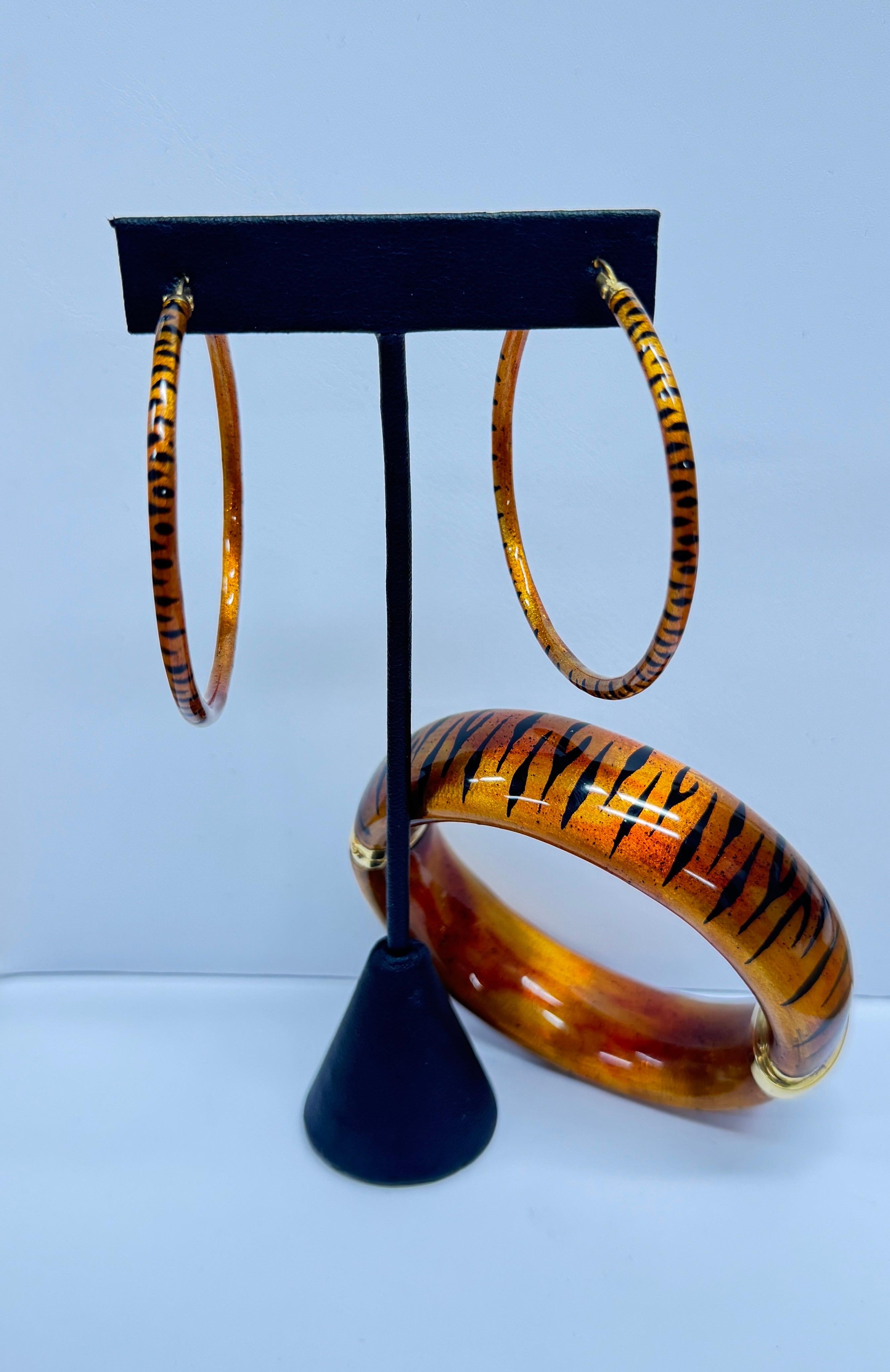 Orecchini a cerchio e bracciale con cerniera in oro 18 carati e smalto ispirati alle strisce di tigre di SOHO - Realizzati a mano in Italia

Questo set di gioielli SOHO è composto da un paio di orecchini a cerchio smaltati a strisce di tigre e da un