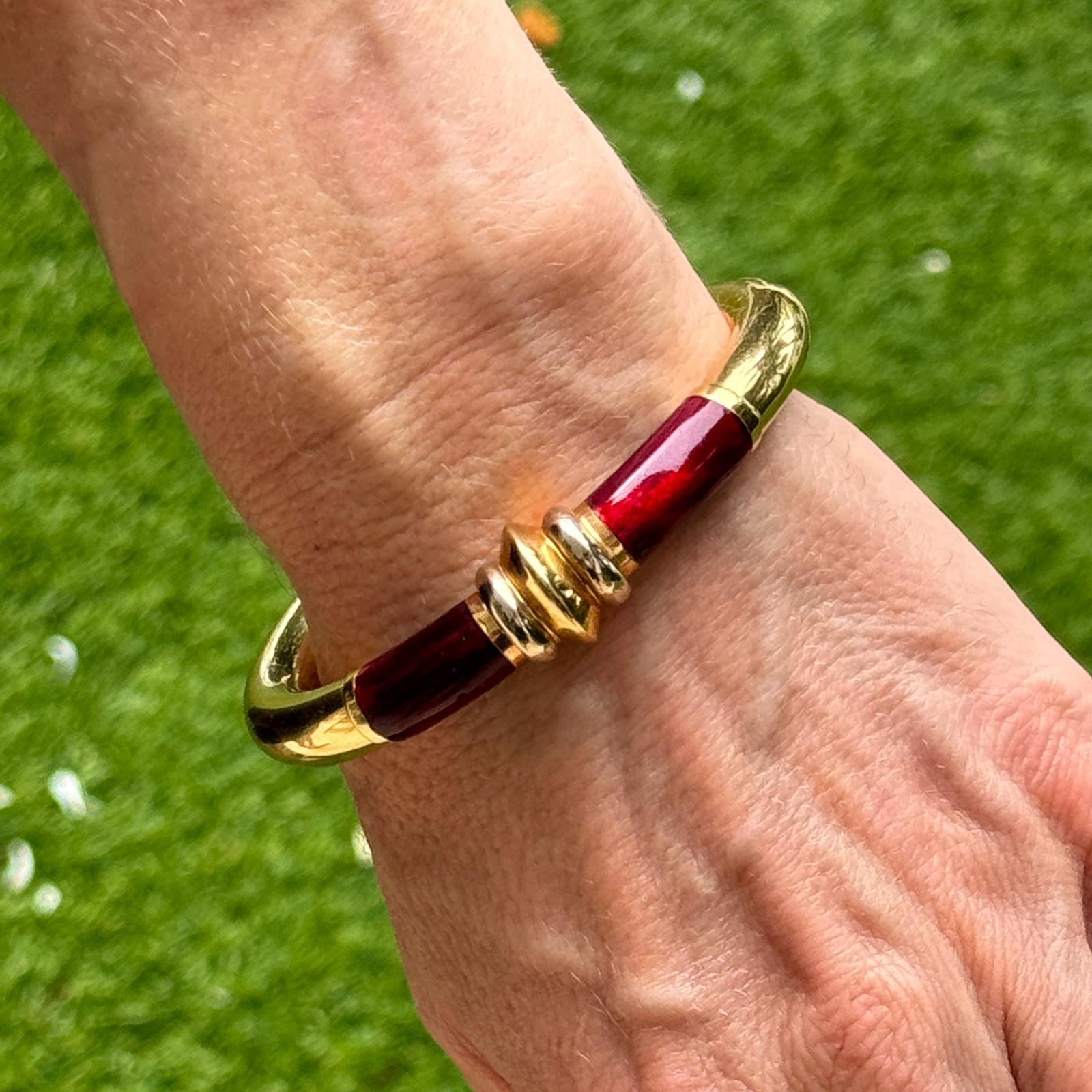 Dieses SOHO Italian Red Enamel Hinged Bangle Bracelet ist ein modernes und elegantes Accessoire, gefertigt aus luxuriösem 18 Karat Gelbgold. Das Armband mit einer Breite von 9 mm und einem Durchmesser von 2,25 Zoll weist eine kräftige rote