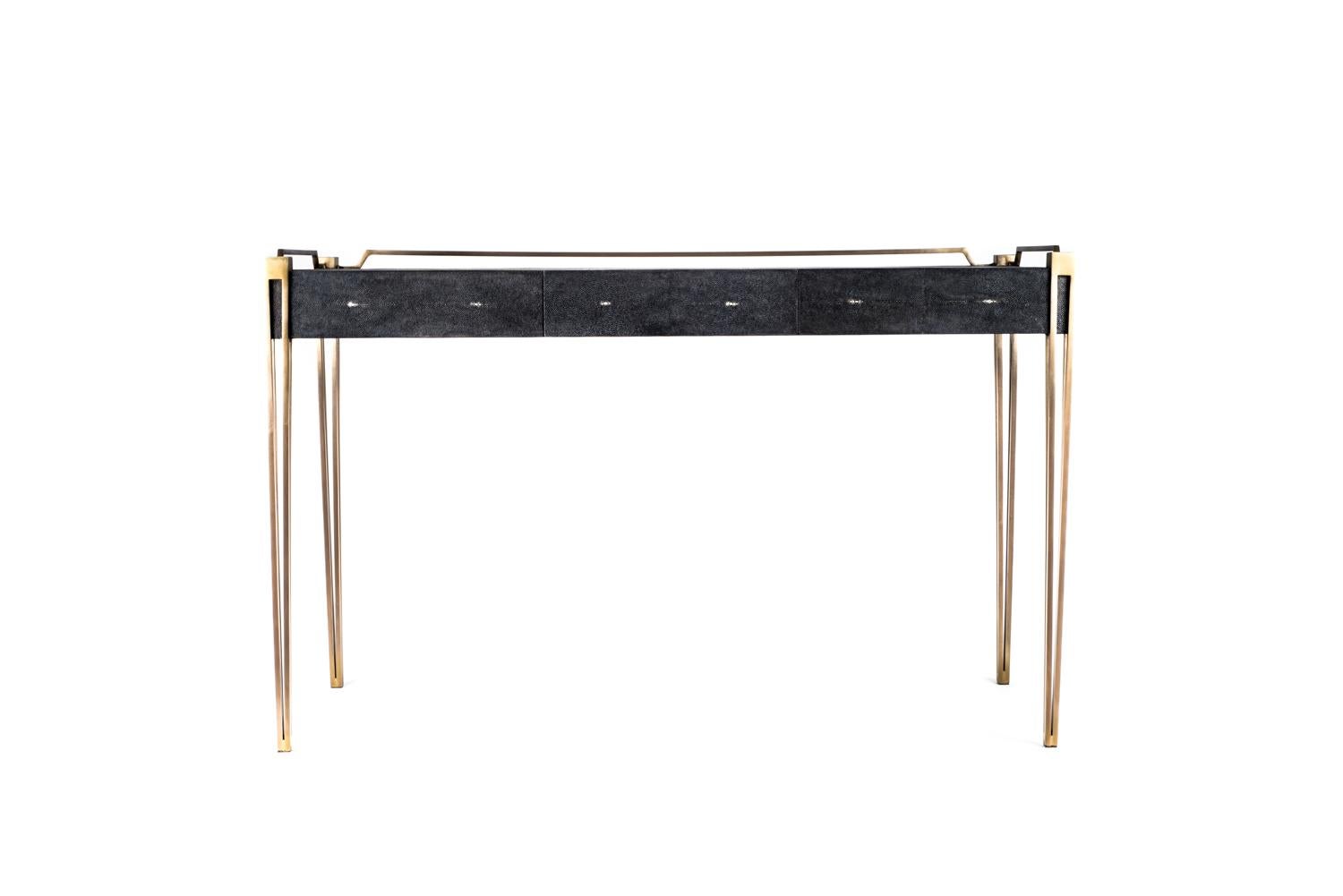 The Soho Writing Desk is the perfect piece for a living room, bedroom or office space that merges vintage and modern sensibility. Add a mirror and this desk becomes a vanity table. The surface of this desk is inlaid in black shagreen, framed with