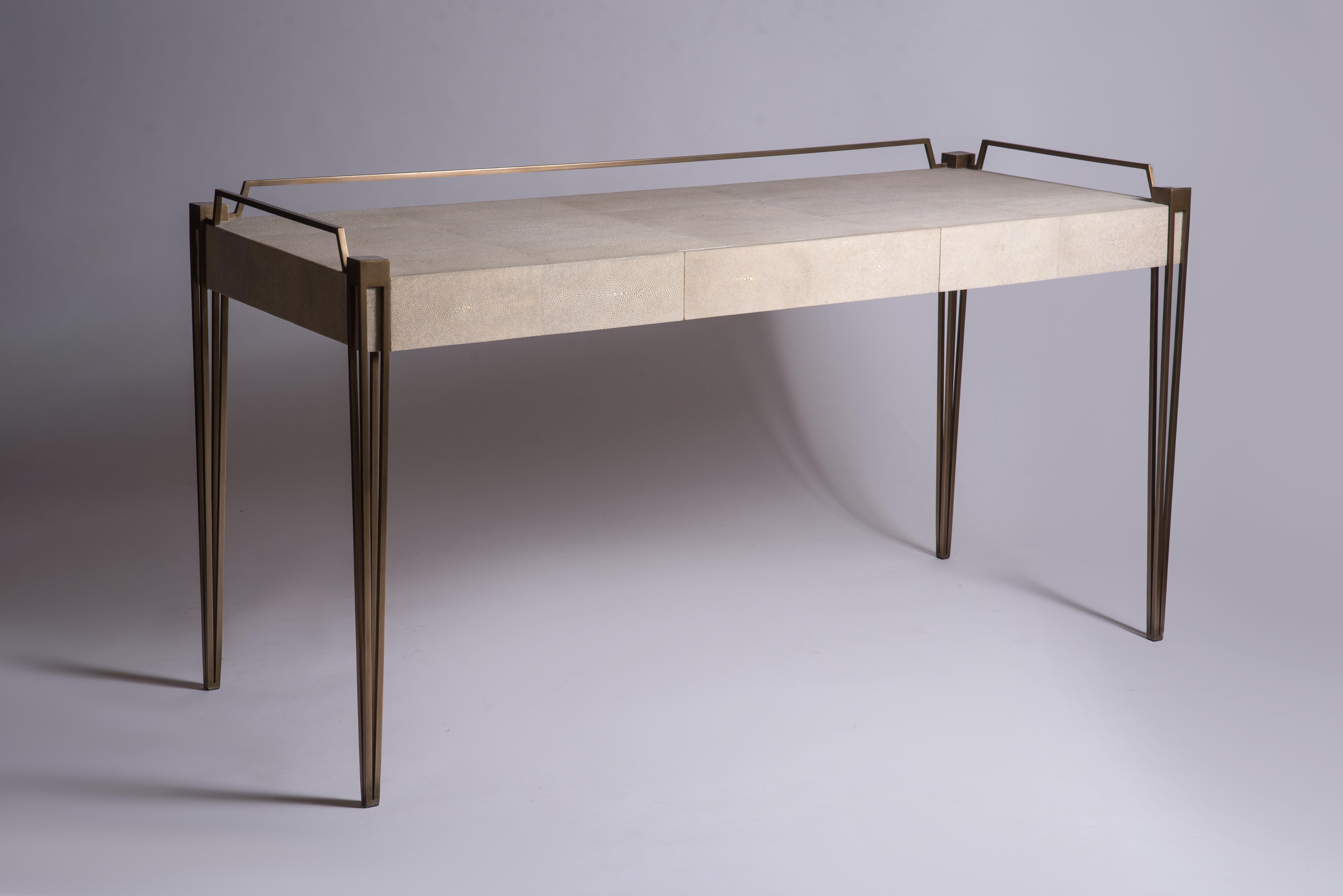 The Soho writing desk is the perfect piece for a living room, bedroom or office space that merges vintage and modern sensibility. Add a mirror and this desk becomes a vanity table. The surface of this desk is inlaid in cream shagreen, framed with