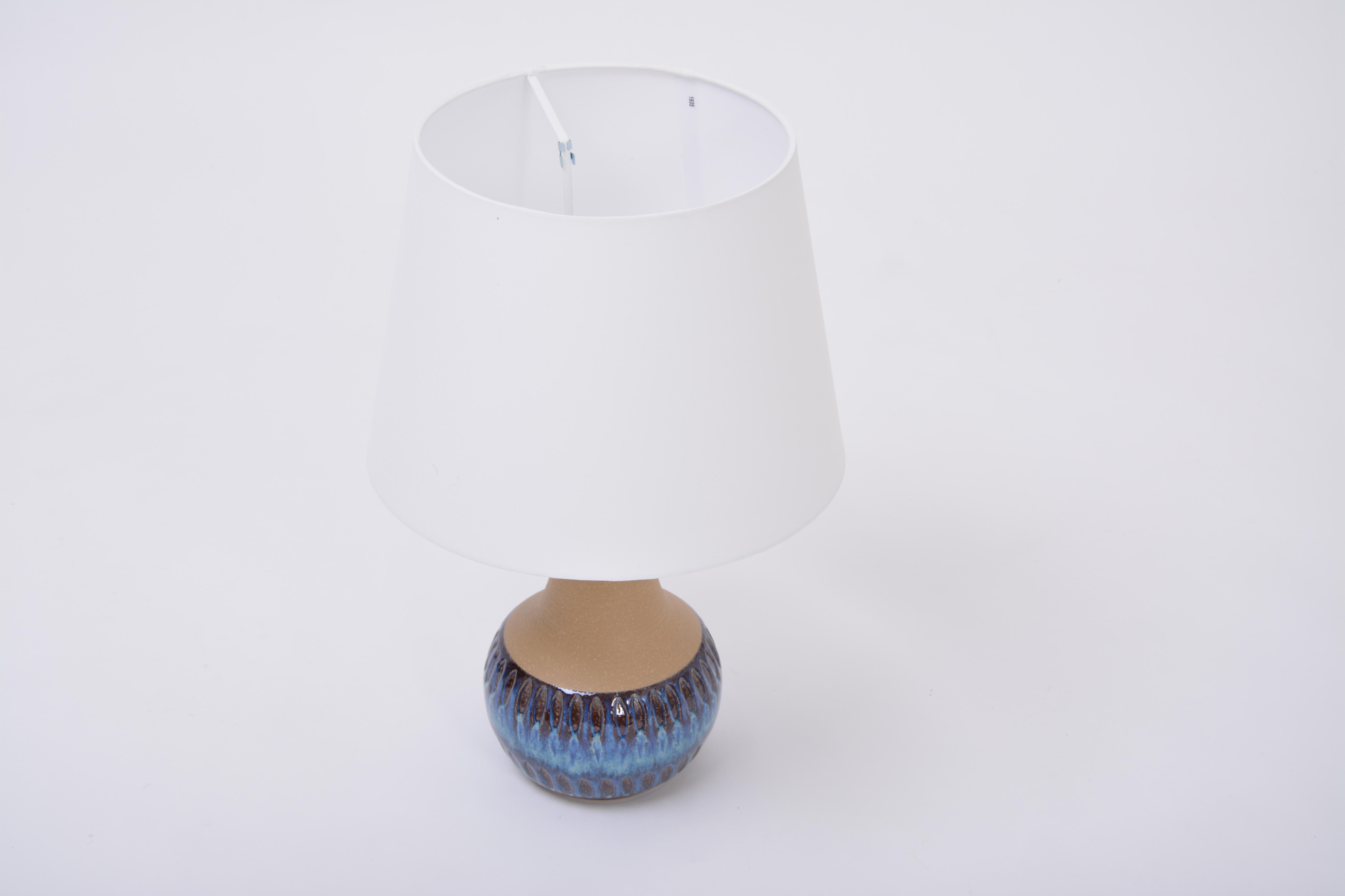 Soholm handmade Danish Mid-Century Modern stoneware lamp with blue ceramic base
Table lamp handmade of stoneware with ceramic glazing in tones of blue. Graphical pattern to the base of the lamp. Produced by Danish company Soholm. The lamp has been