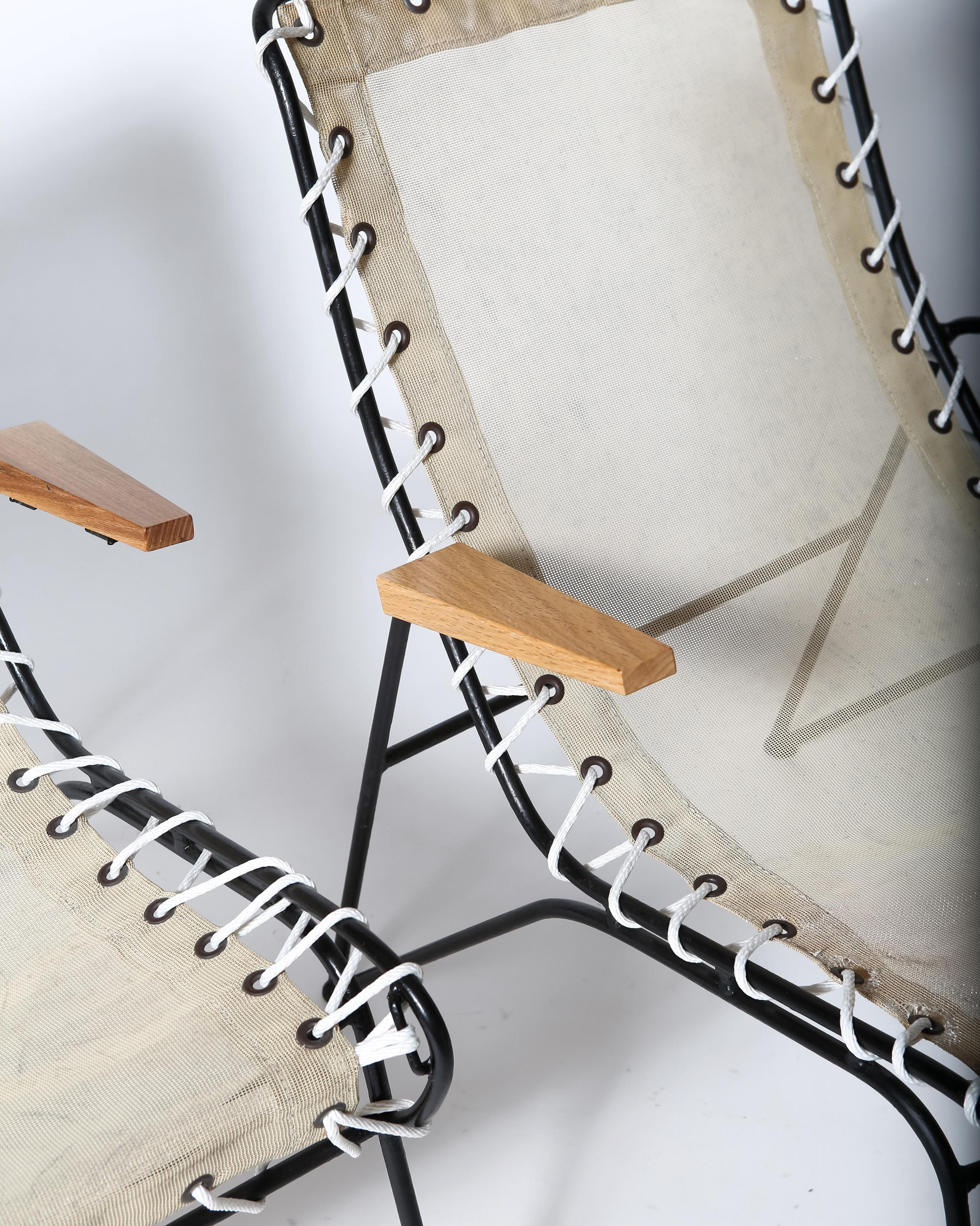 Pair modernist lounge chairs by Pipsan Saarinen-Swanson for Fick’s Reed. Arms of oak, solid wrought iron frame and nylon mesh sling attached by grommets to frame with halyard cord. Very comfortable. Use indoors or out, the look is classic MCM cool.