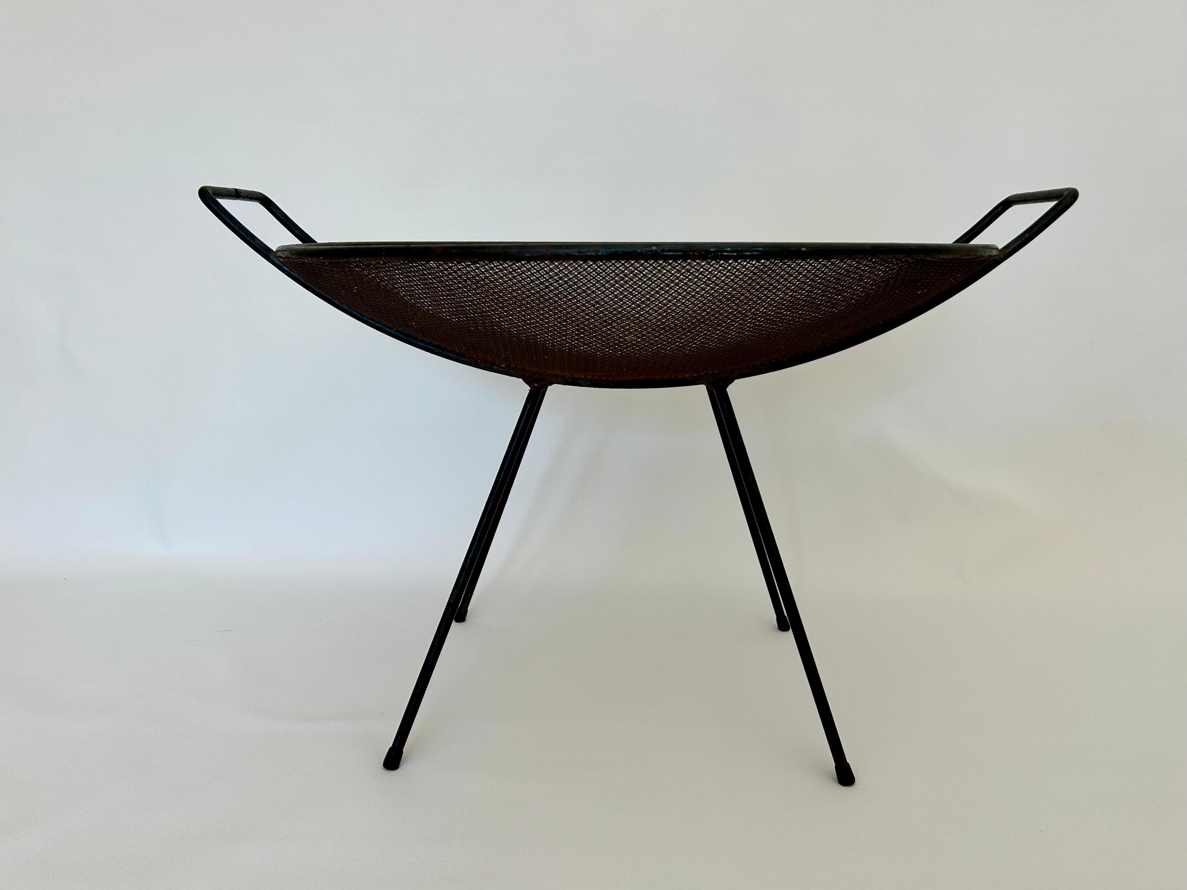 Modernist design.
Form + function.
Enameled steel with wire mesh basket and plastic boots.
Original vintage condition, minor wear with patina.
No damage or repairs.
Solid and sturdy.
Presents well for interiors and collections. 
Great for holding
