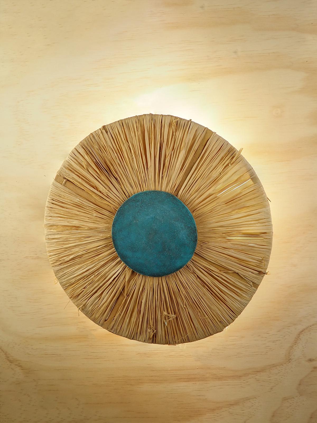Inspirée par l'ombre d'une palapa, cette applique murale à profil bas associe des finitions naturelles et brutes à un design structuré minimal et contemporain. 

 Le corps en grès moucheté est fabriqué à la main à partir d'une plaque d'argile, puis