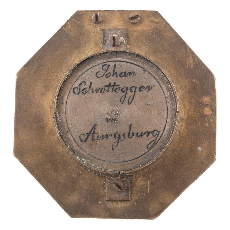 Période : XVIIIe siècle.

Provenance : Allemagne, signé Johan Schrettegger Augsburg.

Dimensions : 5 cm x 5 cm / étui 5,7 cm x 6 cm : 5 cm x 5 cm / étui 5,7 cm x 6 cm.

Cadran solaire horizontal finement sculpté en laiton doré, signé Johan