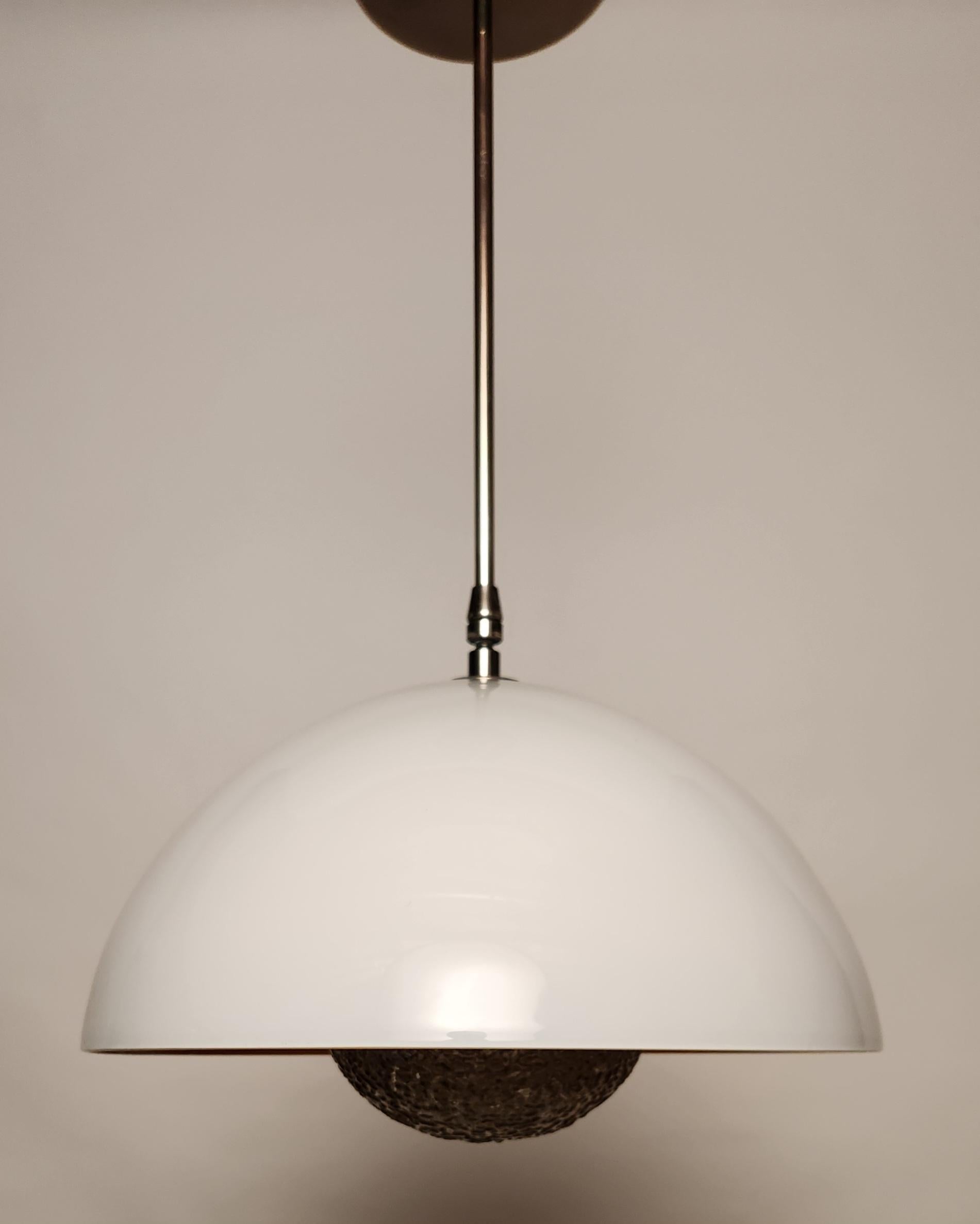 El Colgante Solara explora la relación entre los cuerpos planetarios y el sol emparejando una semicúpula con un difusor esculpido a mano para crear una pieza que imita maravillosamente la interacción estelar de las entidades celestes. Inspirado en