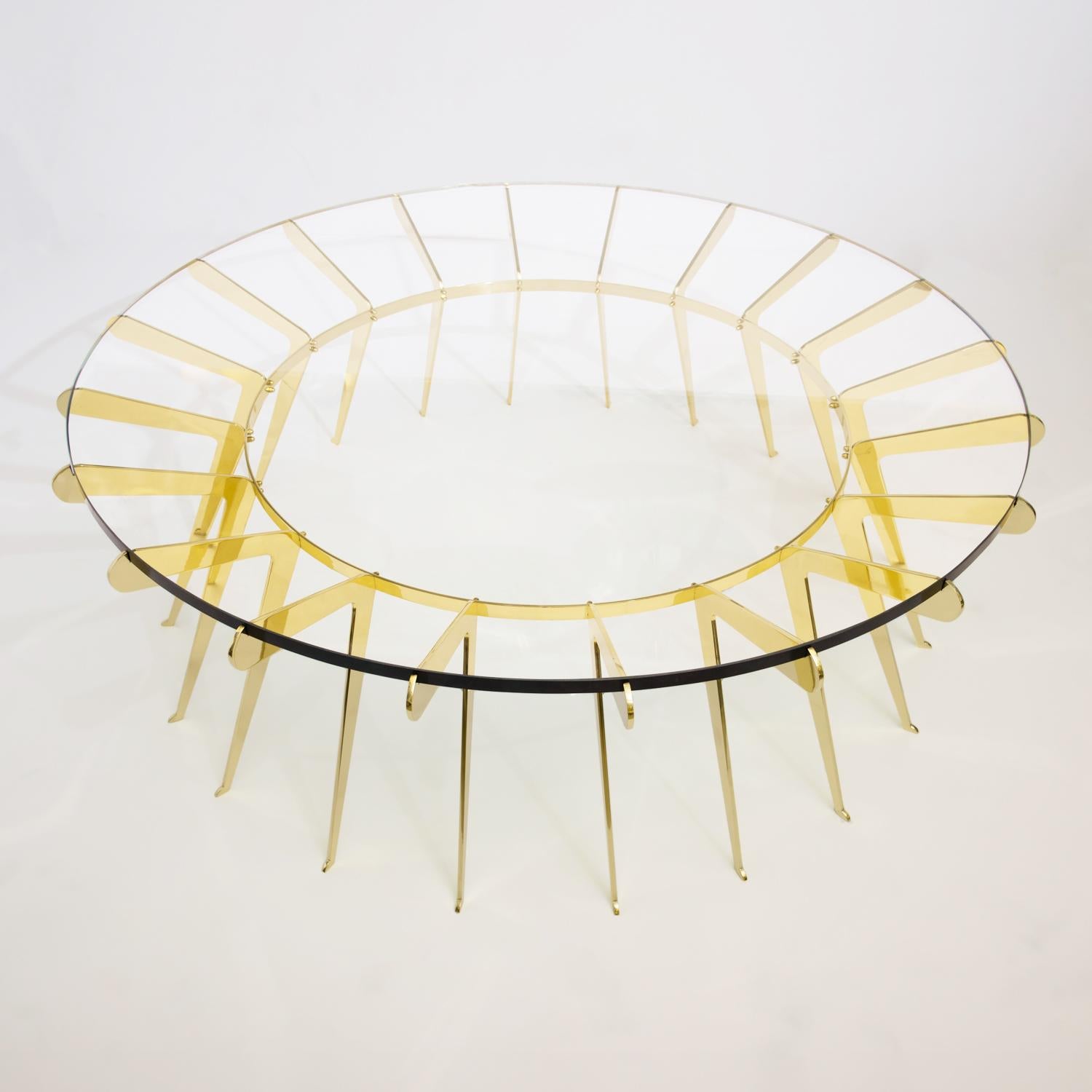 La table Solare joue sur le concept de la force du nombre : de nombreux pieds en laiton délicatement dessinés s'assemblent pour soutenir un épais plateau en verre transparent. Représenté en laiton poli avec un diamètre de 51