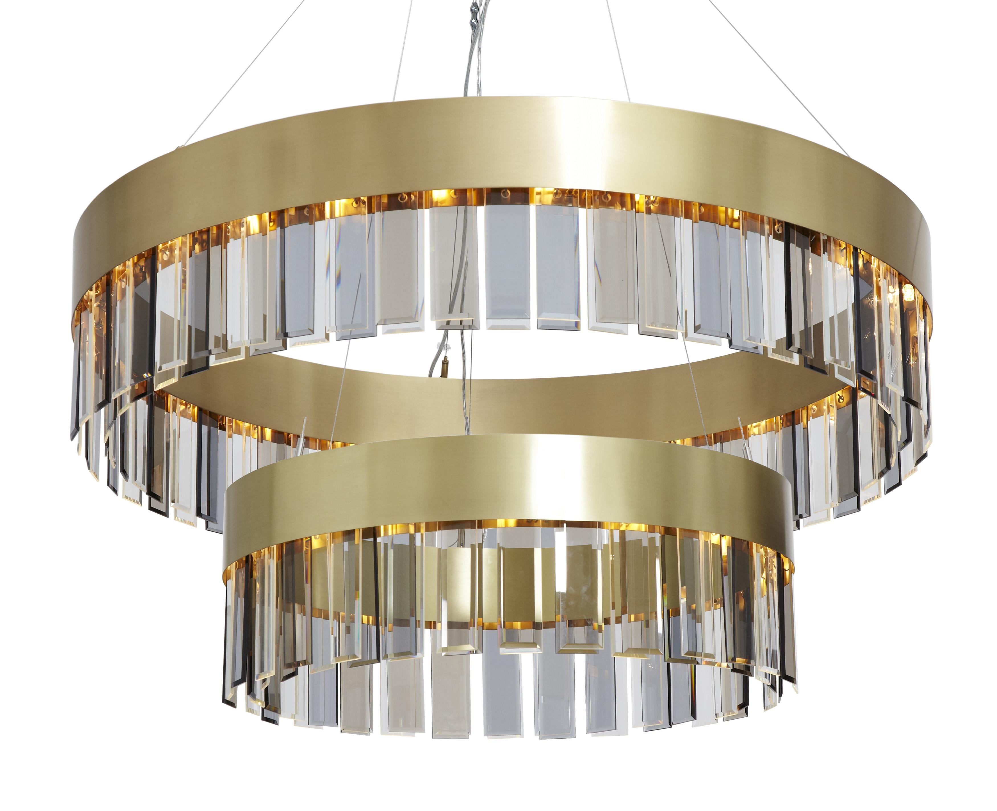 Solaris twin pendant by CTO Lighting
Materials: satin brass with cut glass drops and stainless steel suspension wire/clear flex
Dimensions: H 40 (min) x W 110 cm 

All our lamps can be wired according to each country. If sold to the USA it will