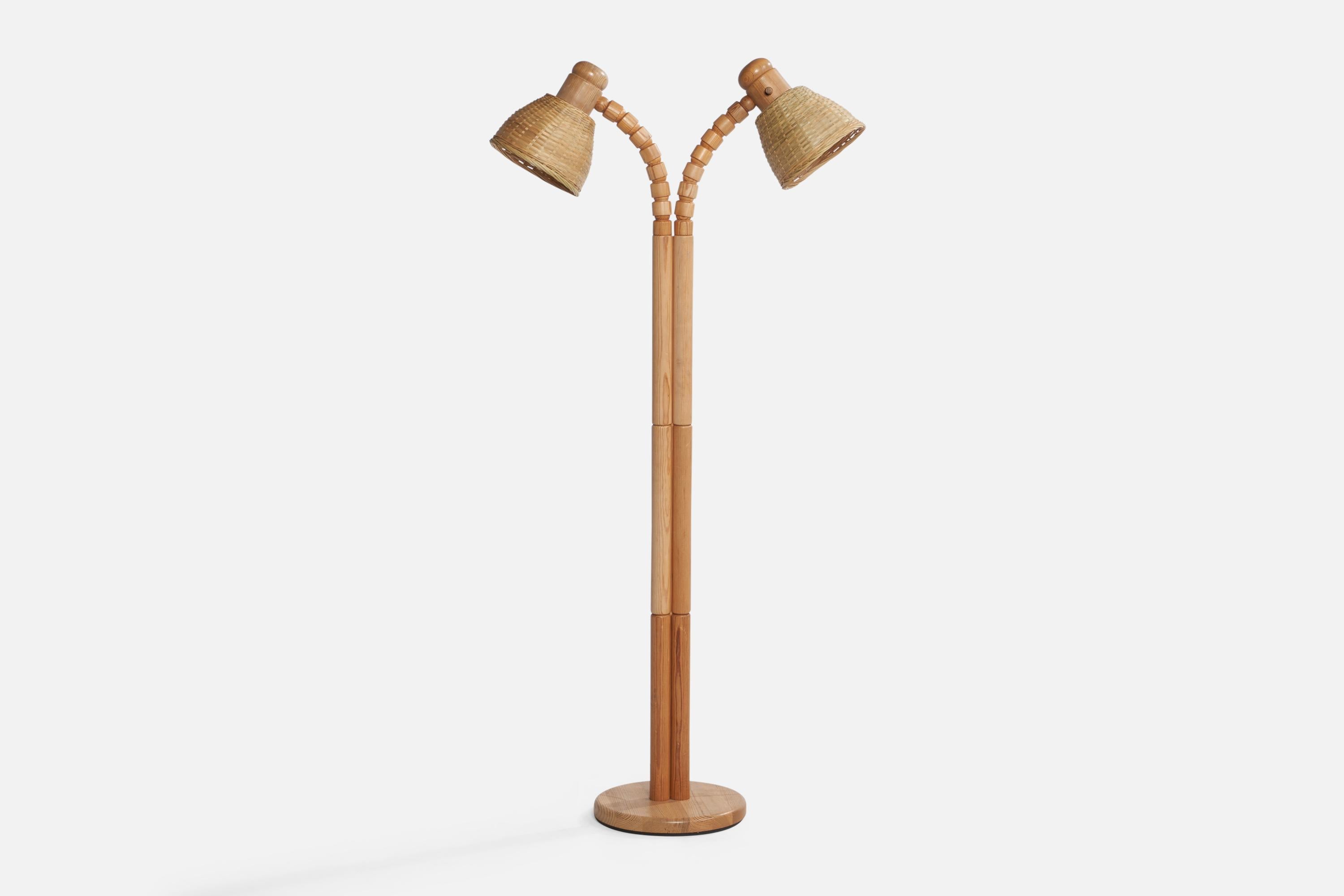 An adjustable two-armed pine and rattan floor lamp designed and produced in Sweden, c. 1970s.

Overall Dimensions (inches): 50.75” x 27.75” W x 11” D. Stated dimensions include shades.
Dimensions vary based on position of lights. Stated dimensions