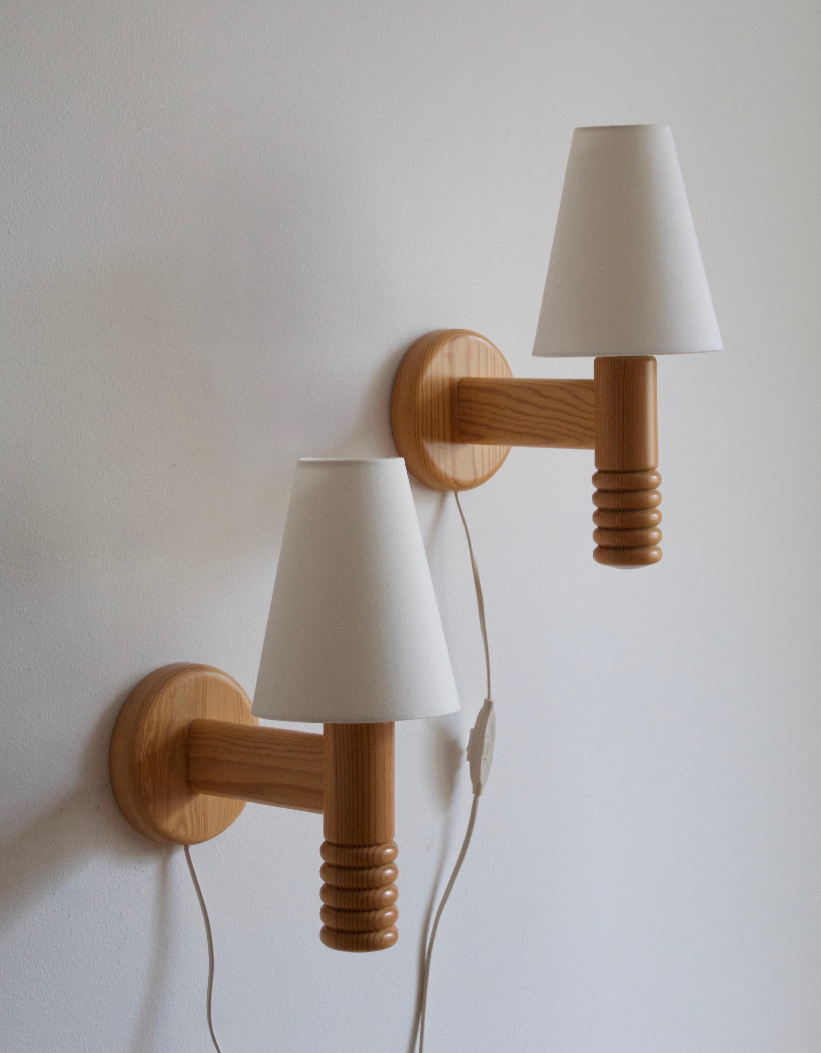 A pair of wall lights / sconces. Produced by Solbackens Svarveri, Sweden, circa 1970s. Brand new lampshades. 

Stated dimensions include lampshades as illustrated.