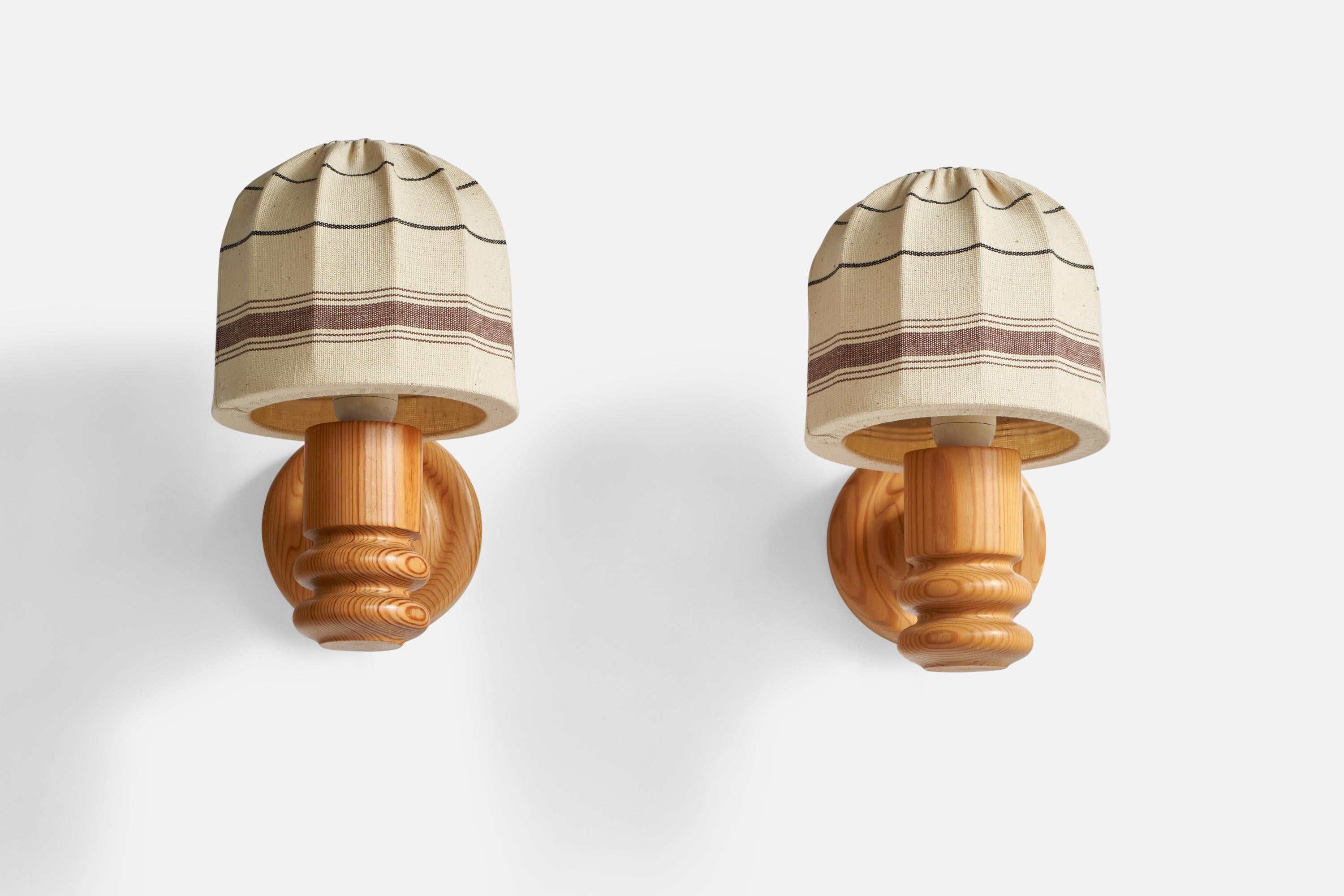 A pair of pine and off-white brown woven fabric wall lights designed and produced by Solbackens Svarveri, Sweden, 1970s.

Overall Dimensions (inches): 11.85” H x 7.05” W x 10.25” D
Back Plate Dimensions (inches): 5.35” Diameter x 1.15” Depth
Bulb