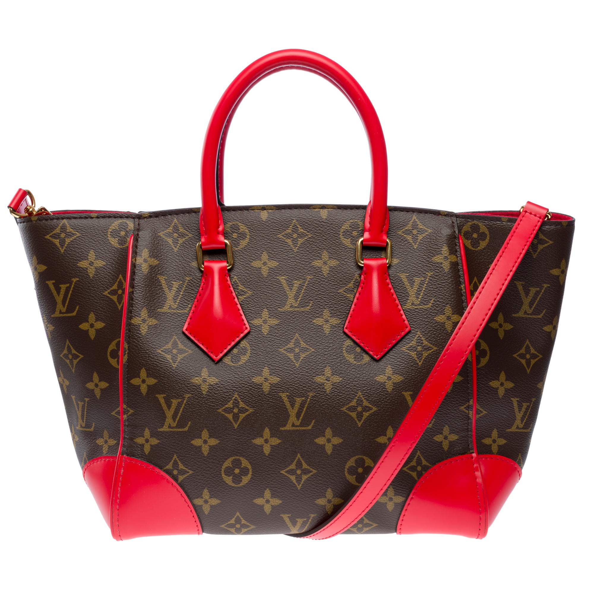 Louis​ ​Vuitton​ ​Phenix​ ​handbag​ ​strap​ ​in​ ​brown​ ​and​ ​red​ ​Monogram​ ​canvas.​ ​This​ ​model​ ​features​ ​two​ ​red​ ​cow​ ​leather​ ​handles,​ ​a​ ​gold​ ​metal​ ​trim.​ ​It​ ​can​ ​be​ ​worn​ ​by​ ​hand,​​ ​shoulder​ ​or