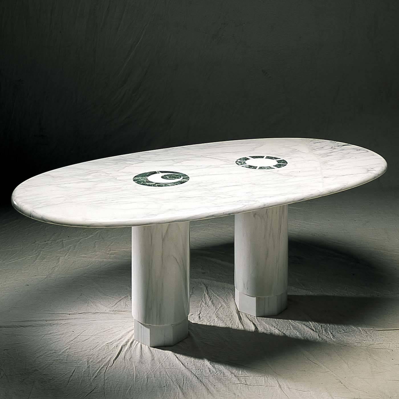 A timeless design by Adolfo Natalini for a dining table that combines classic materials with modern silhouette. The entire structure is made of Carrara marble and features a stunning oval top resting on two smooth pillar-shaped supports with an