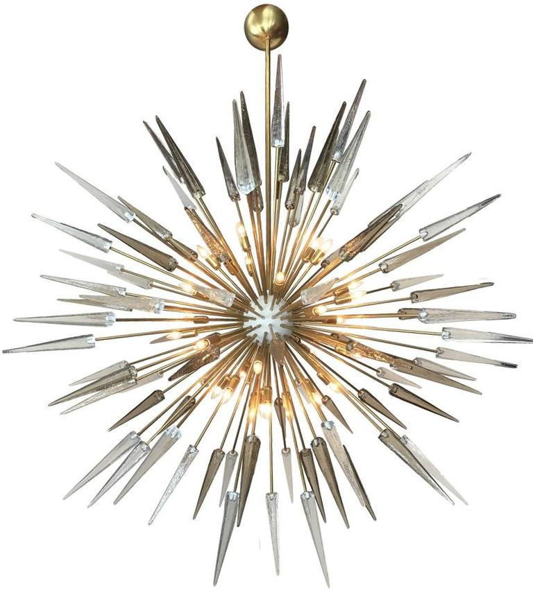 Italian modern sputnik chandelier with clear and smoky Murano glass shards spikes, mounted on natural unlacquered brass frame with white enameled centre, designed by Fabio Bergomi for Fabio Ltd / Made in Italy
30 lights / E12 or E14 type / max 40W
