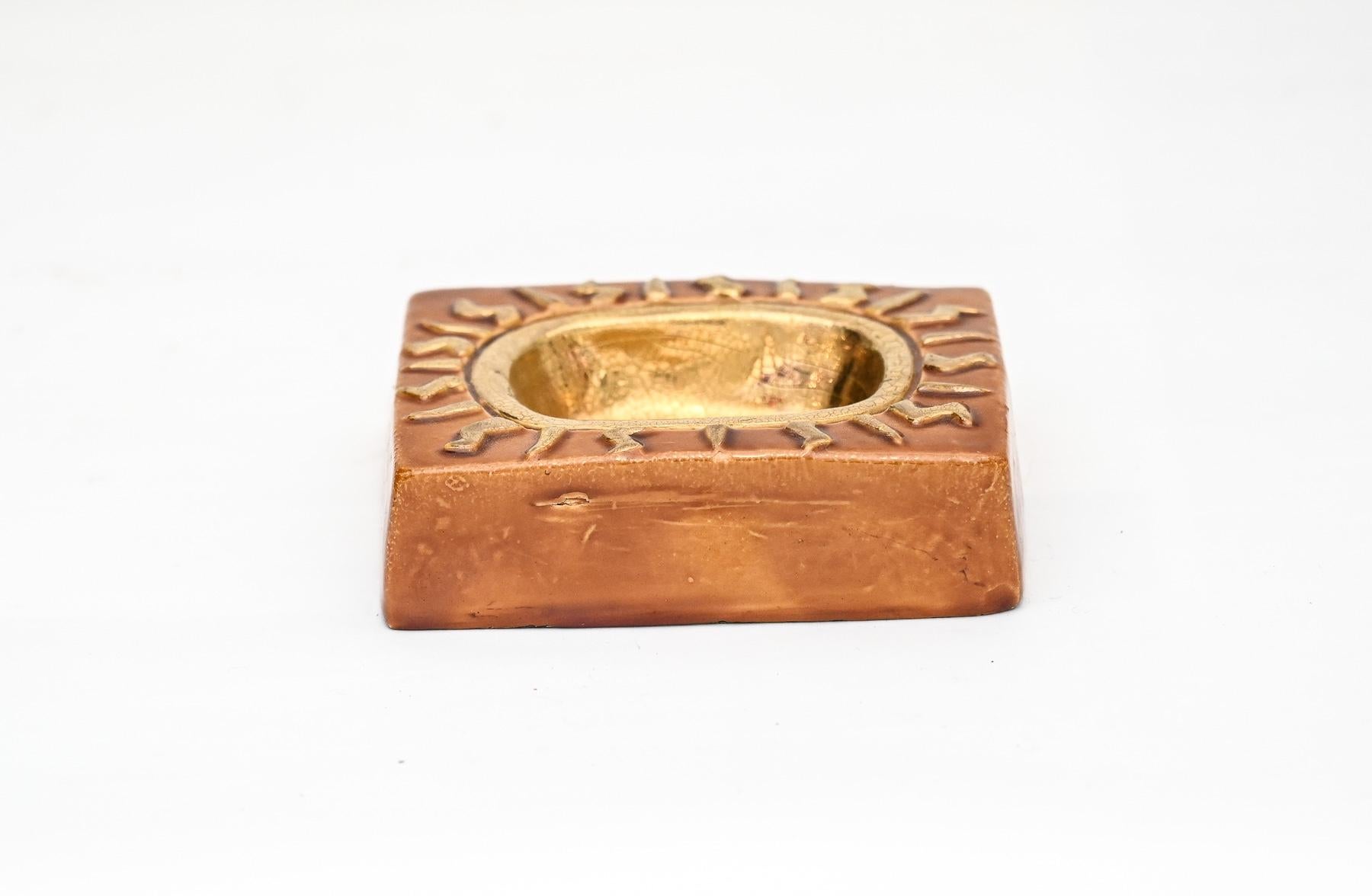 charming “Soleil” jewellery tray by mithe espelt, embossed and glazed earthenware with crackled gold.

France, circa 1958

Identical glaze to the model illustrated on page 20 of the Mithé Espelt book “the discreet luxury of the everyday” by Antoine