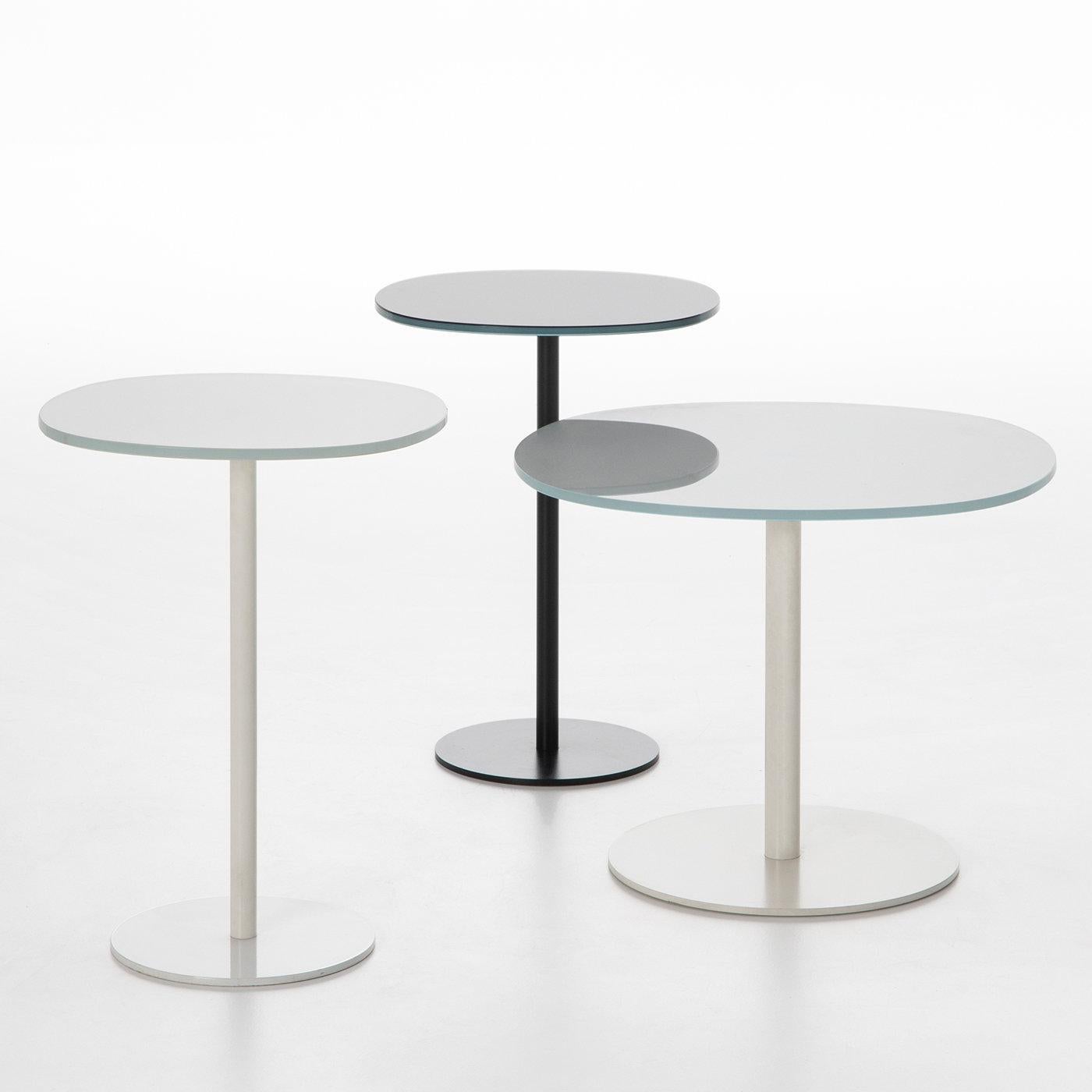 This side table by Piero Lissoni exemplifies how minimalist lines can be uplifted by subtle yet impressive detail. Raised on a black-lacquered metal base comprising a round plate from which stems slender cylindrical support, the glass top