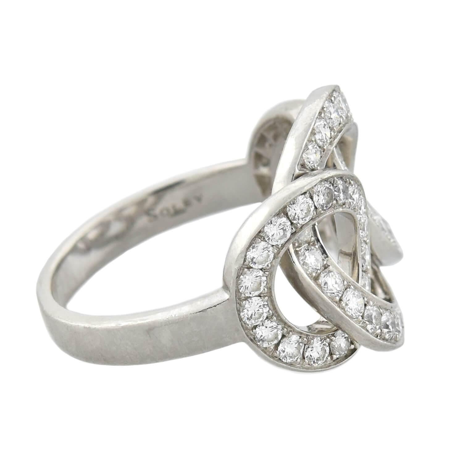 A fabulous contemporary diamond ring from well-known London jewelry designer Soley! Crafted in platinum, this bold piece features three diamond-encrusted rings that intertwine and loop together. Each open circle is lined with modern Brilliant Cut