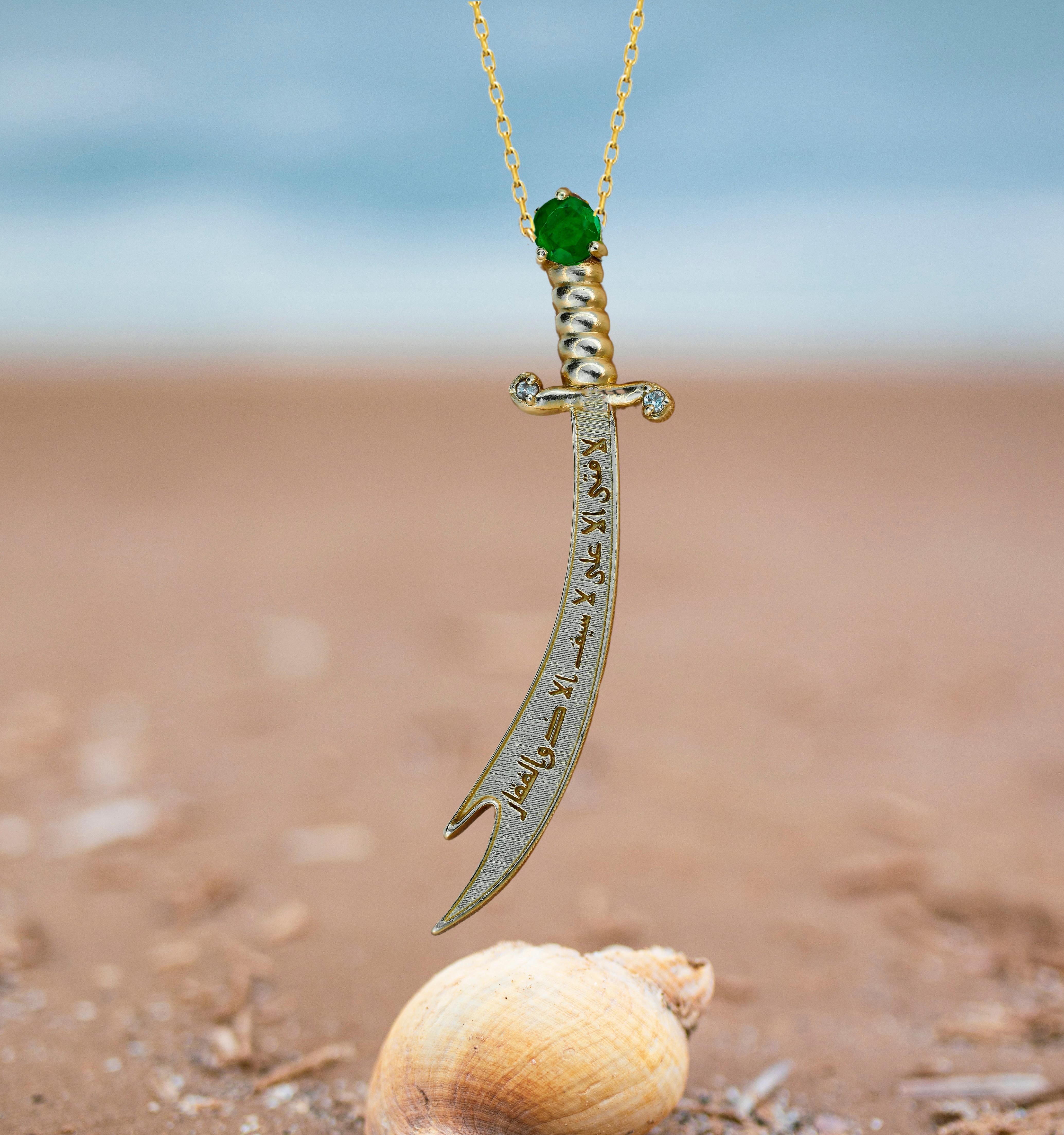 Solid 14 kt solid gold zulfiqar sword pendant with natural emerald and diamonds. May birthstone.
Islamic Hazrat Imam Ali ibn Abi Talib علي Zulfiqar Zulfikar double Sword.
Size: 35 x 7.5 mm.
Total weight: 1.70 g.

Gemstones:
Natural emerald: weight -