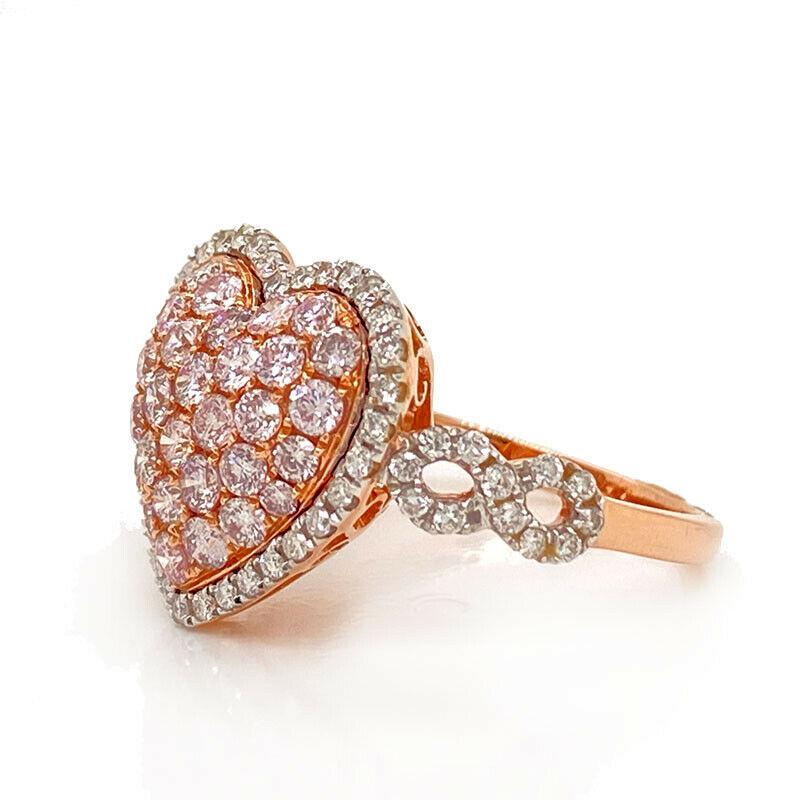 Excellent condition. This solid 14K rose gold ring in the shape of a heart features 33 genuine pink diamonds weighing approximately 1.15CTTW and and 58 genuine white diamonds weighing approximately 0.58CTTW. The ring is a size 7.25 and weighs 3.5