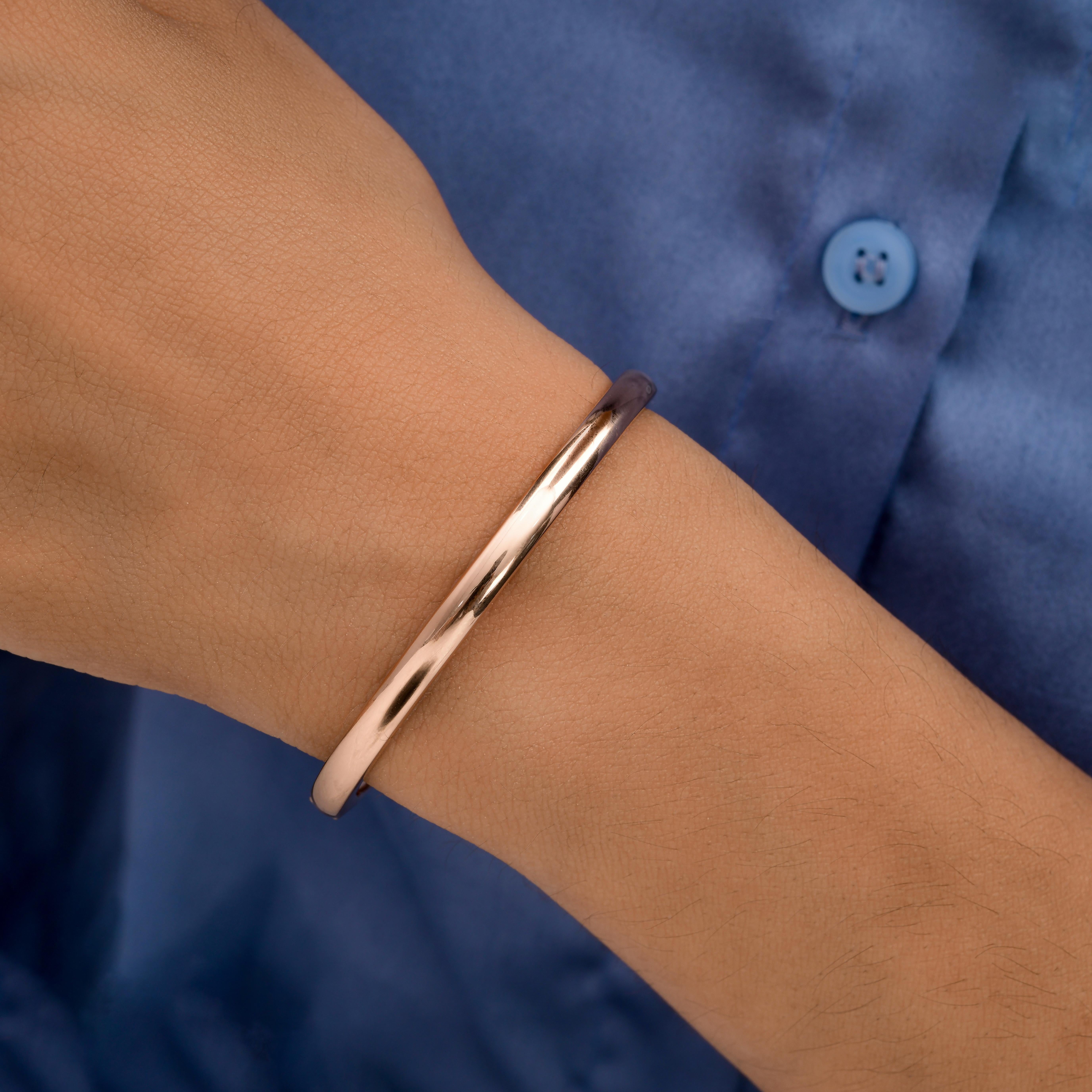 Bracelet unisexe en or rose massif 14k Cadeau d'anniversaire
Le bracelet présente une élégante silhouette de manchette ouverte façonnée en or rose. Le profil tubulaire arrondi offre à la fois confort et style, en permettant un ajustement en douceur